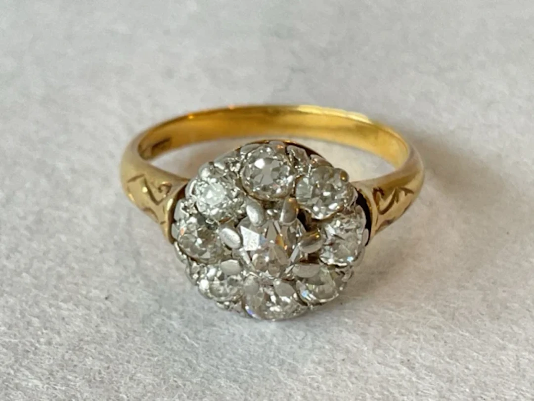 An antique 18ct gold & platinum cluster ring set with 9 claw set old