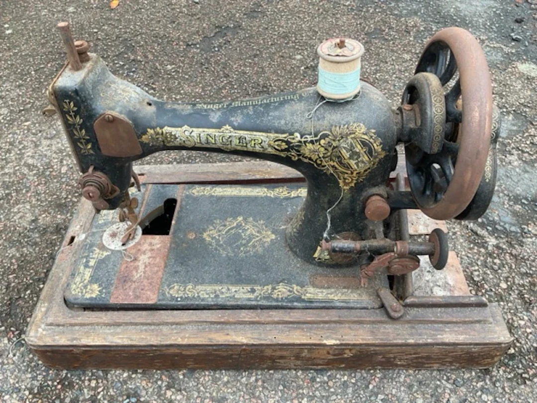 A rusty old Singer sewing machine with gilt decoration to cast iron