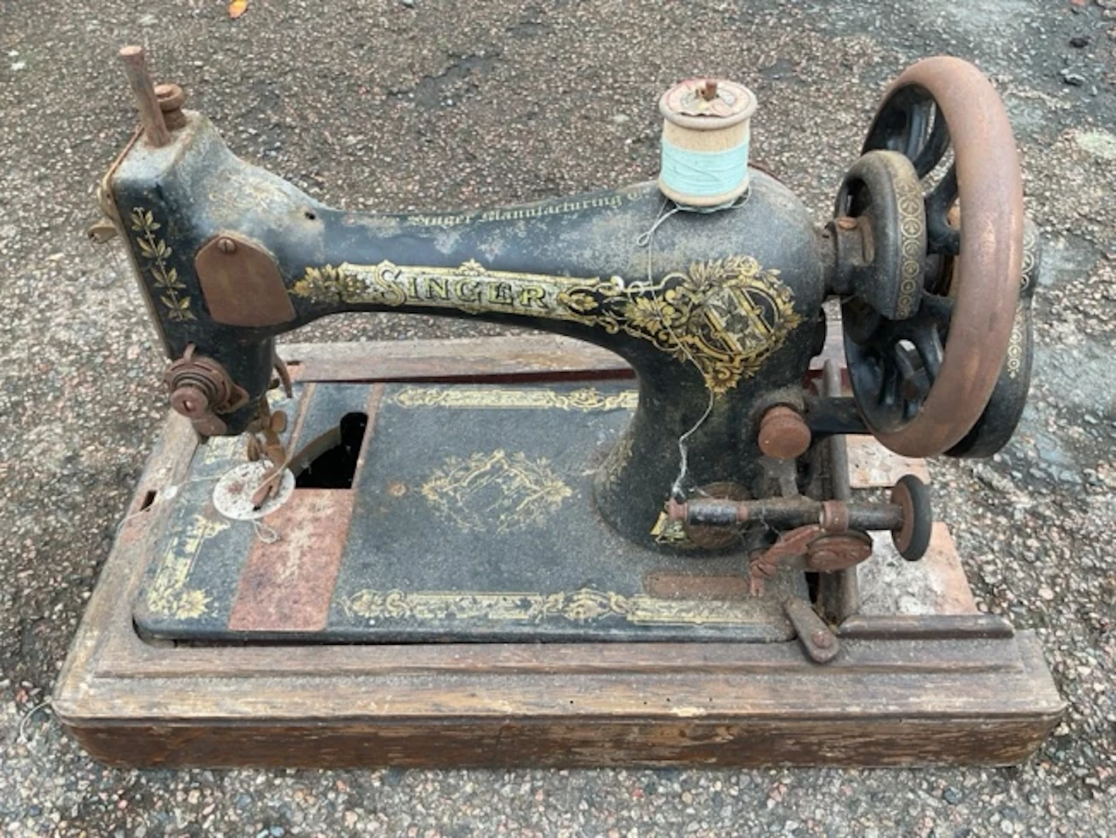 A rusty old Singer sewing machine with gilt decoration to cast iron