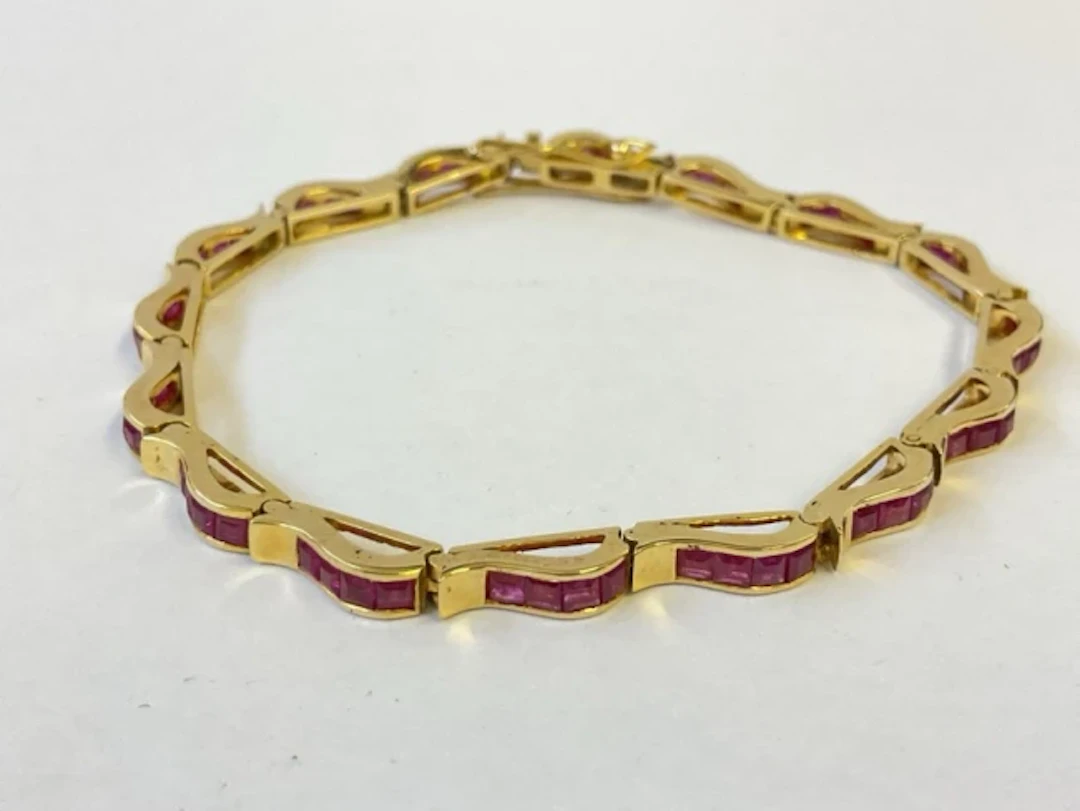 An 18ct gold ruby bracelet, each link having four channel set stones.