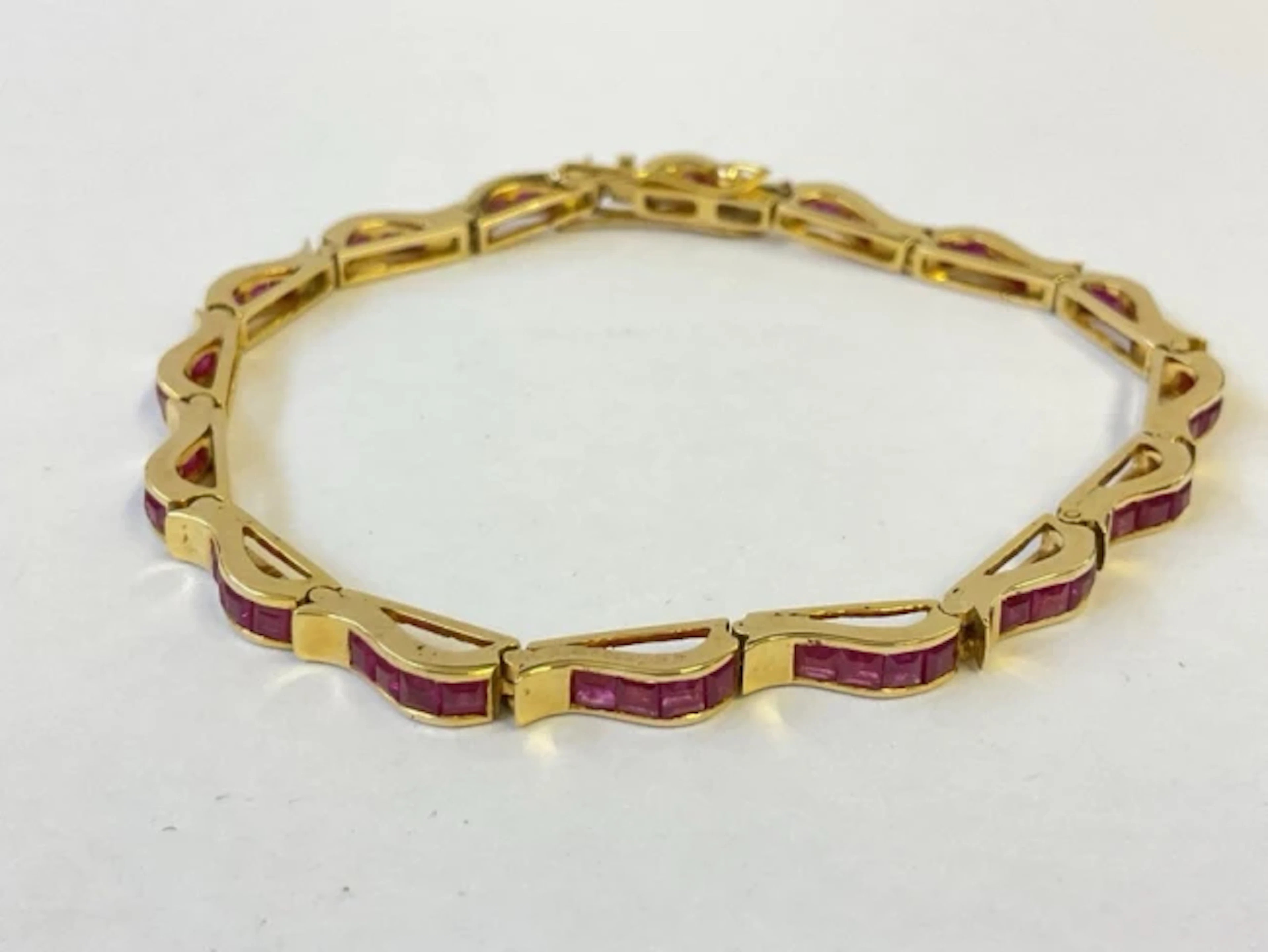 An 18ct gold ruby bracelet, each link having four channel set stones.