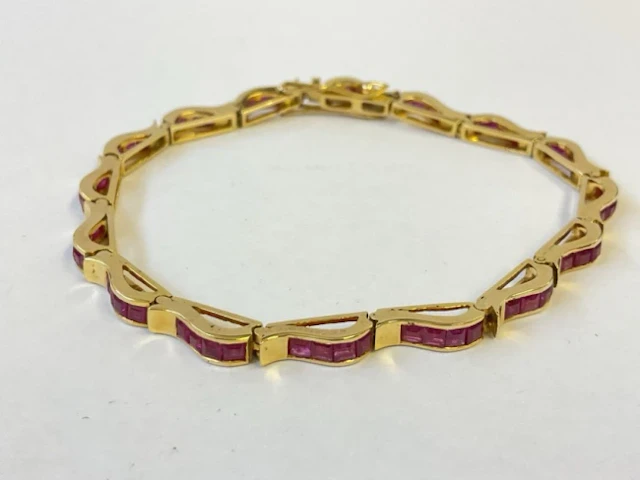 An 18ct gold ruby bracelet, each link channel set with four stones.