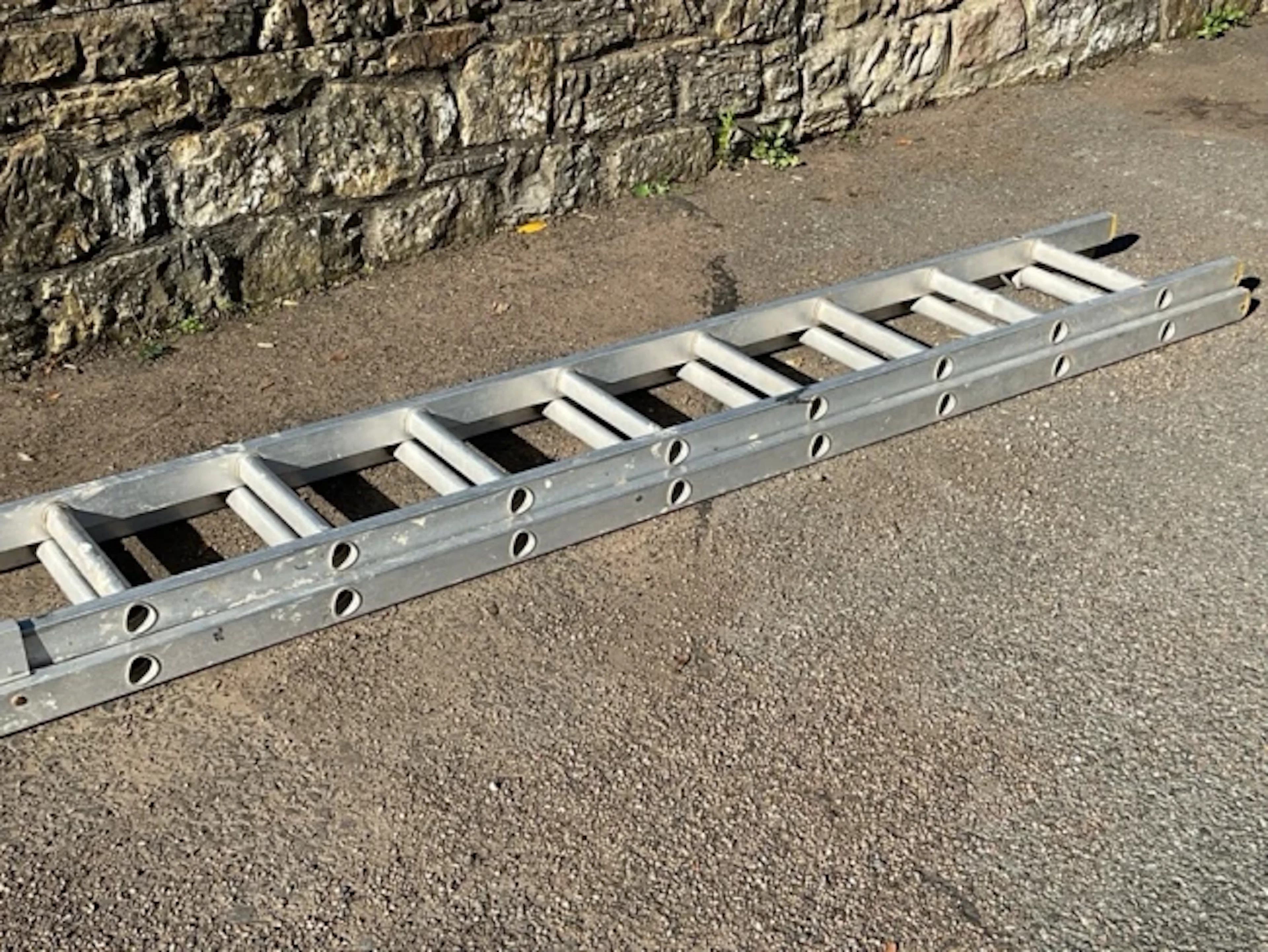 A two-piece 8ft aluminium extending ladder, each section having eight