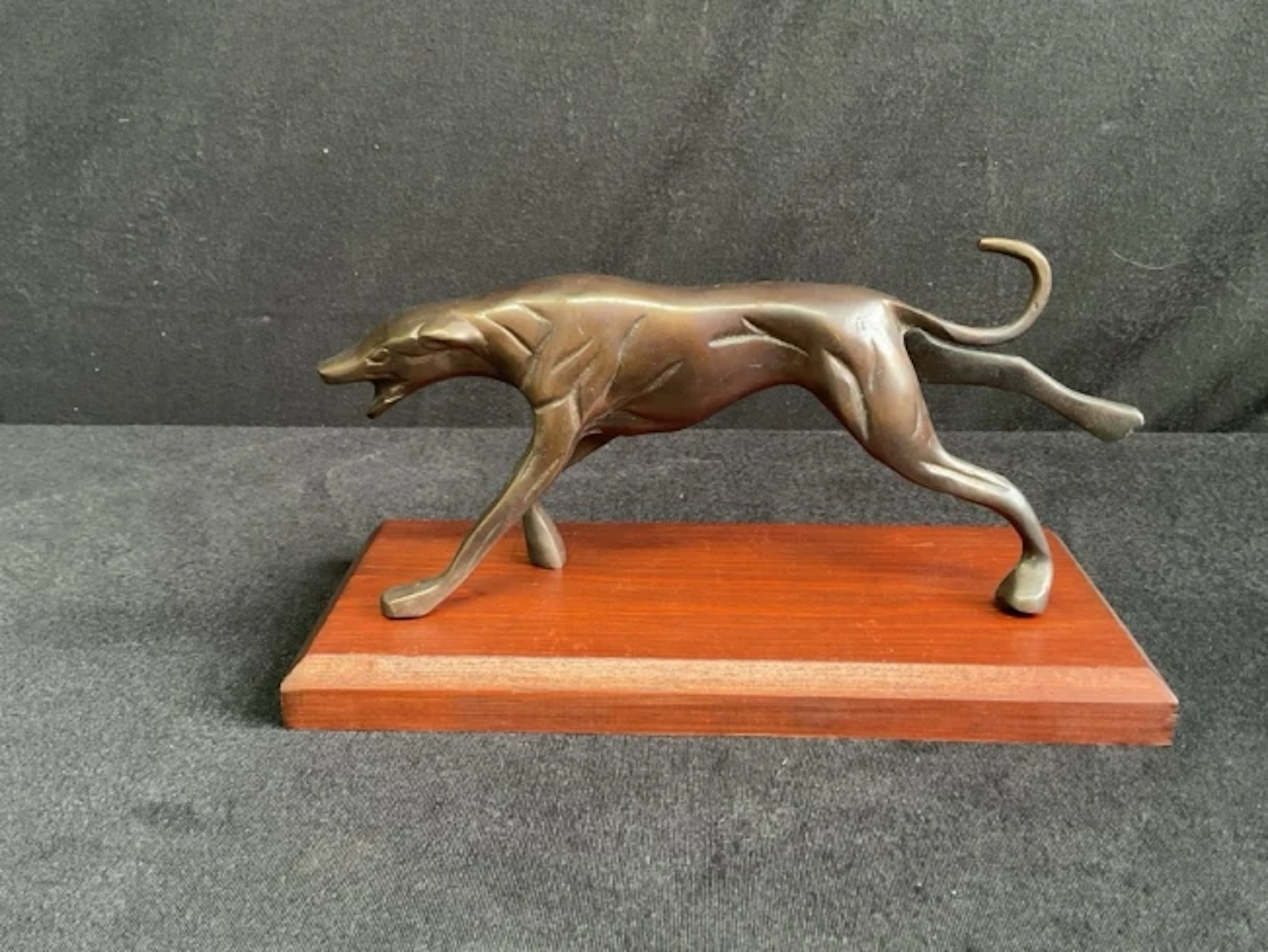 A deco style bronze figure of a sprinting greyhound on a rectangular