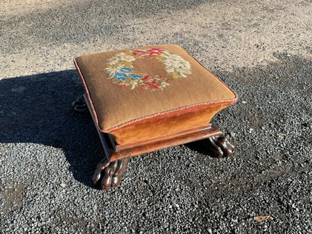 A square Victorian mahogany footstool with floral tapestry needlework