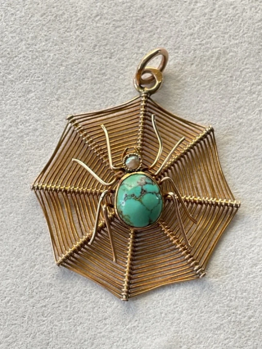 A 9ct gold spider pendant set with turquoise & pearl on octagonal