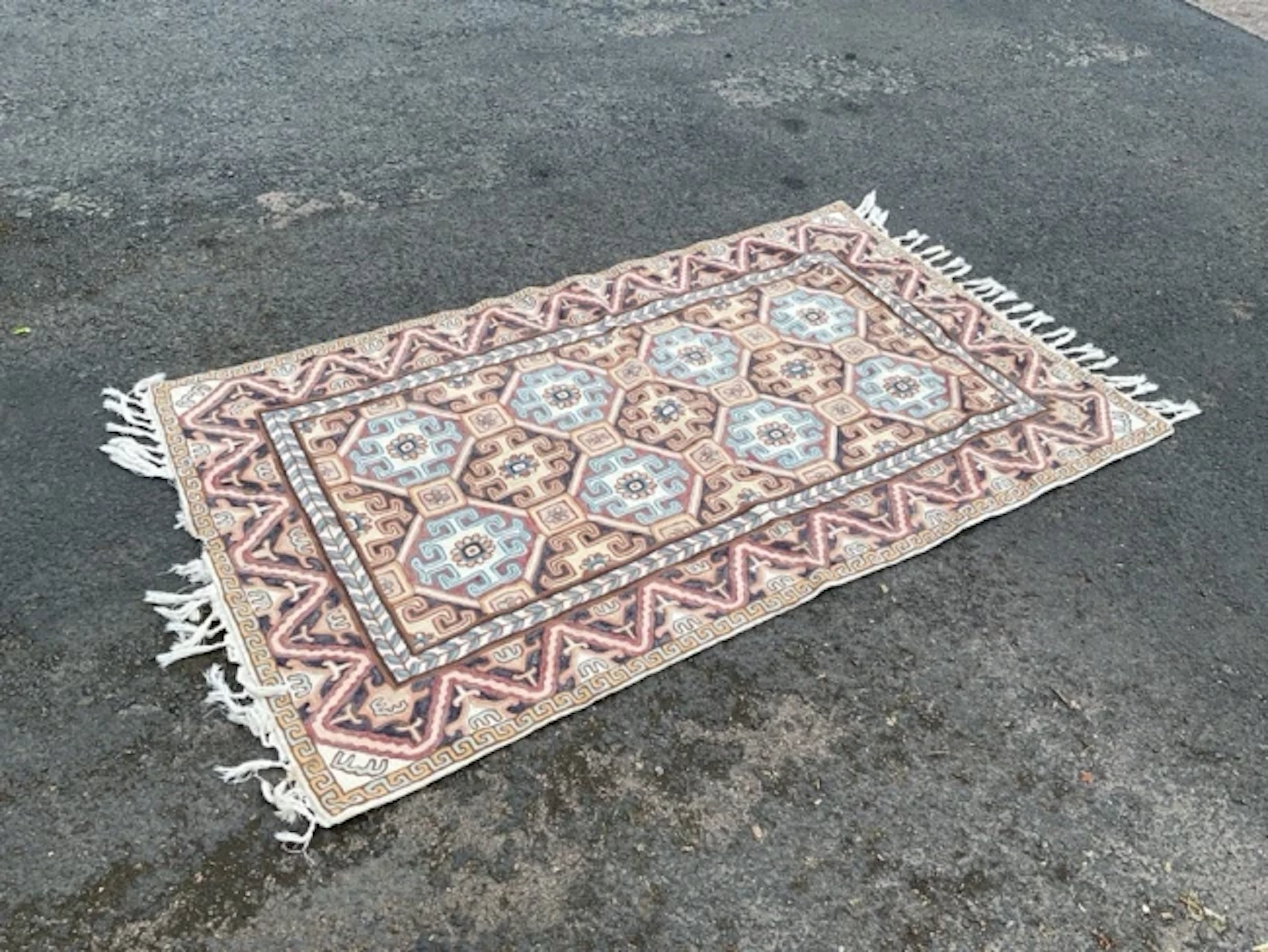 A Kashmiri chainstitch embroidered rug worked in wools on a cotton