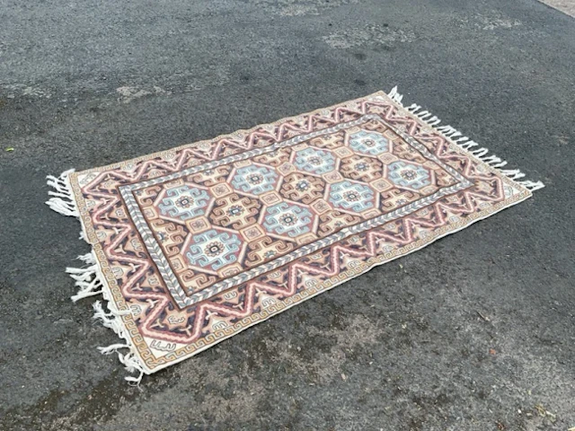 A Kashmiri chainstitch embroidered rug worked in wools on a cotton