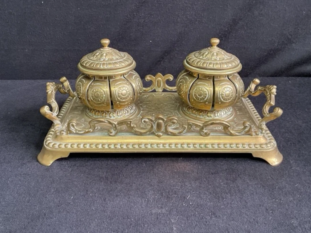 A Victorian brass inkstand with twin melon shaped pots with hinged