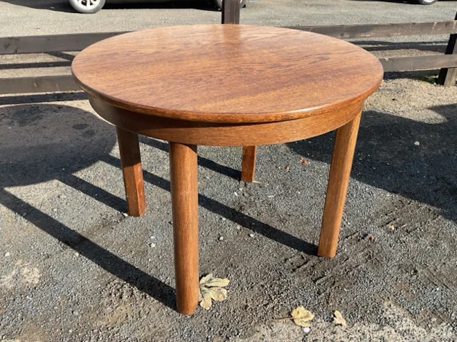A circular modern oak table with plain apron, raised on rounded rectangular