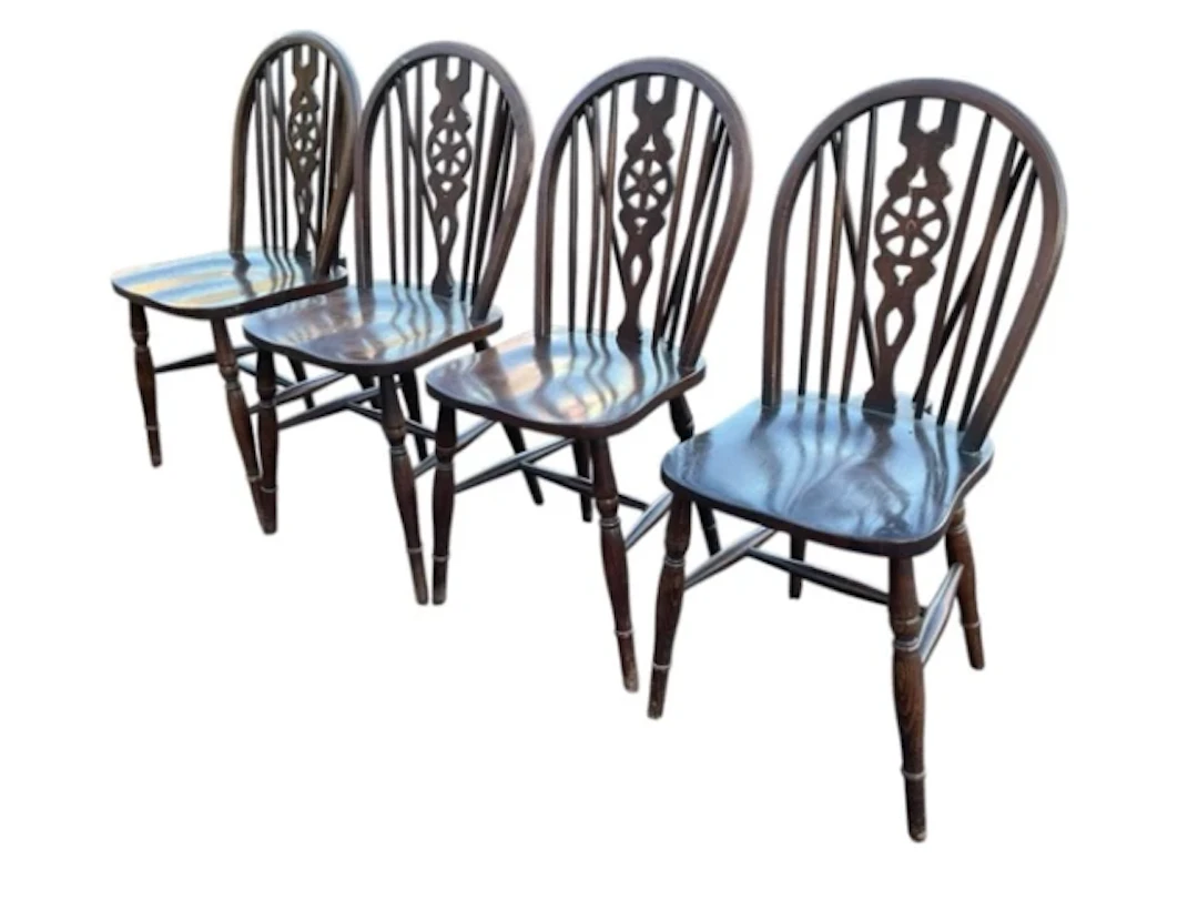 A set of four stained hardwood wheelback chairs, the hooped backs