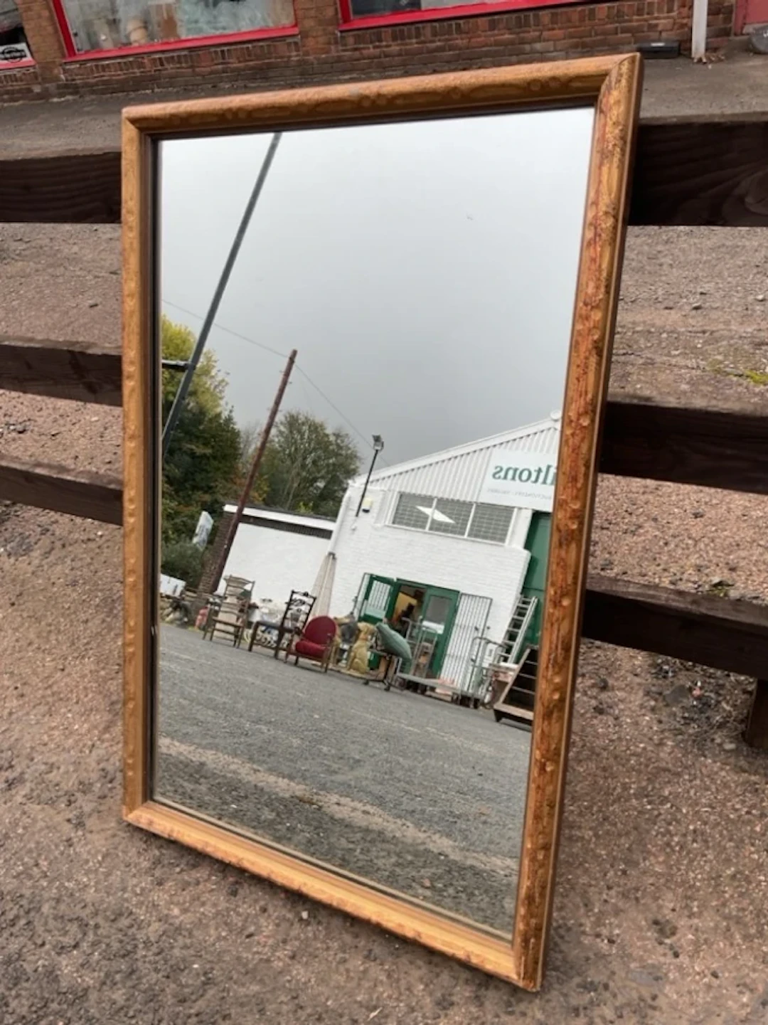 A rectangular mirror in antiqued gilt cushion moulded frame. (22.25in