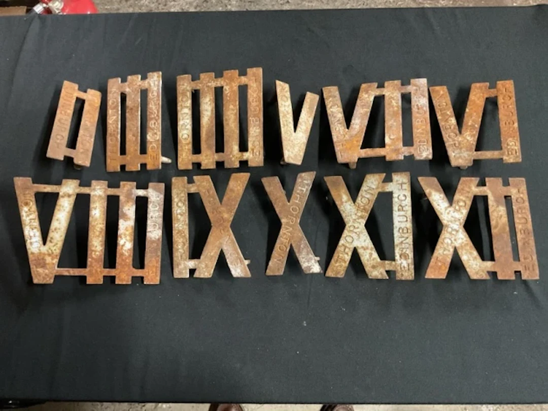 A set of eleven cast iron roman numeral clock golf markers by Thornton