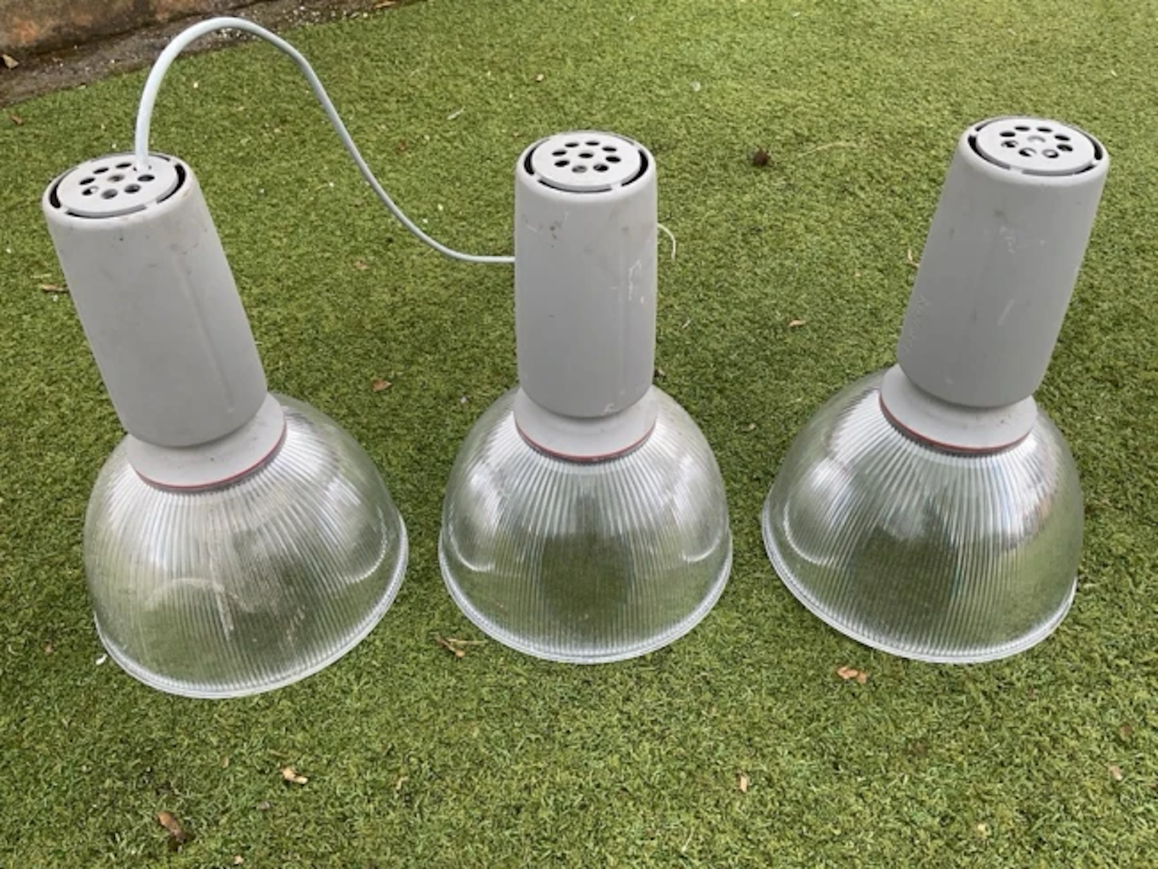 A set of three contemporary hanging lights with silvered ribbed bowl