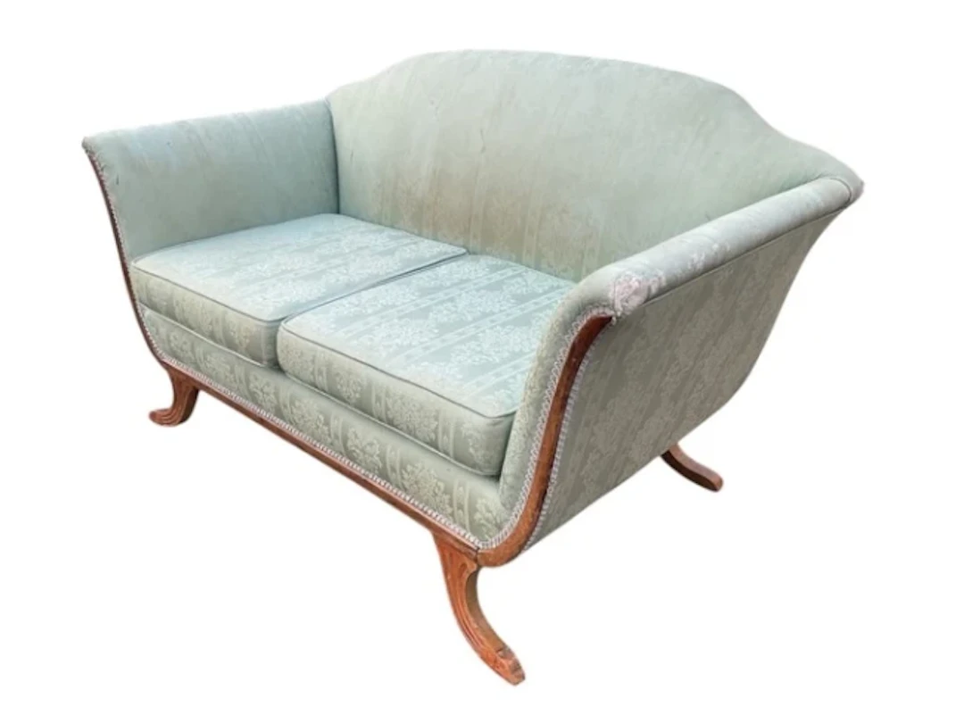A regency style bateau sofa with arched back and flared arms framing