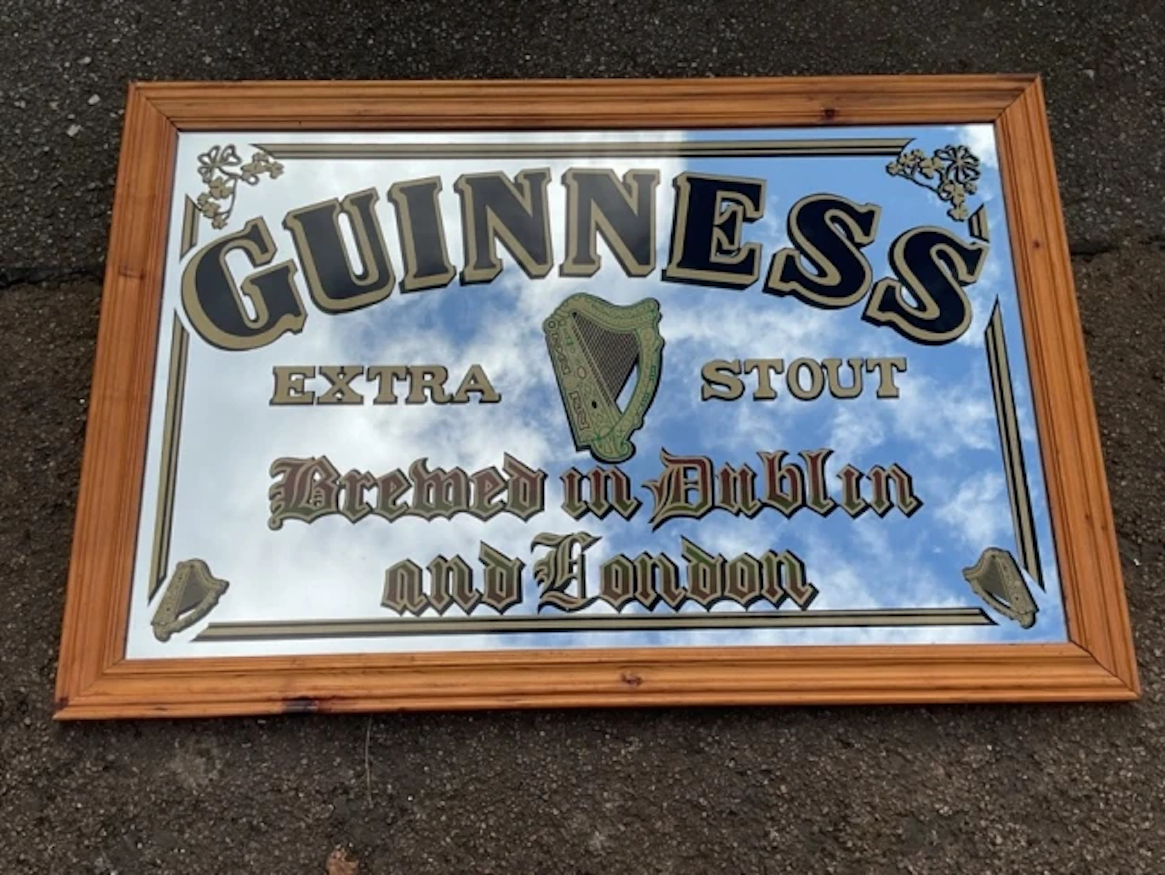 A moulded pine framed rectangular reverse-printed advertising mirror