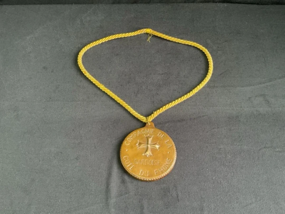 A heavy bronze ceremonial medallion of office on a silk cord for the