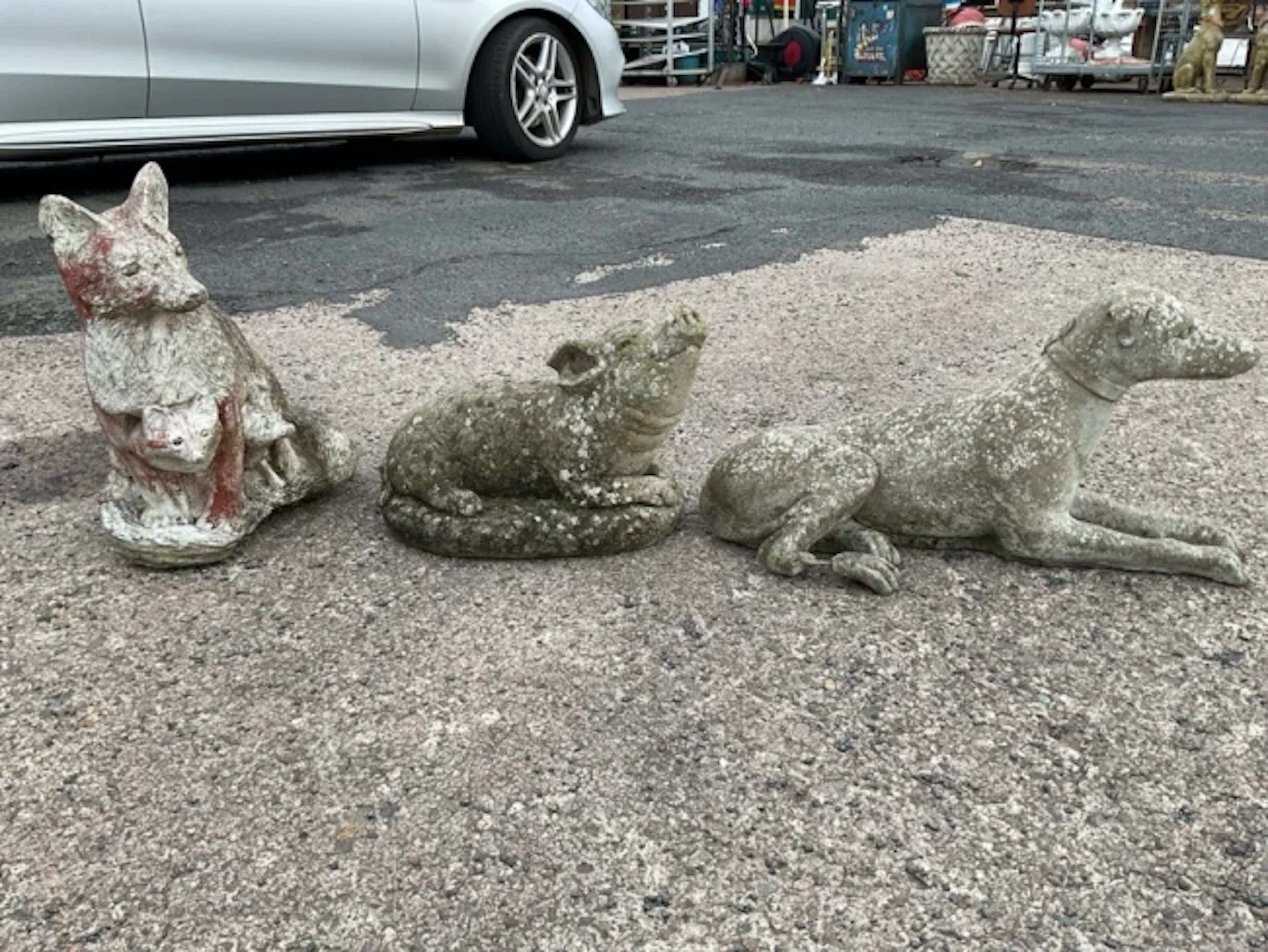 Three composition stone garden animal ornaments - a fox with cubs