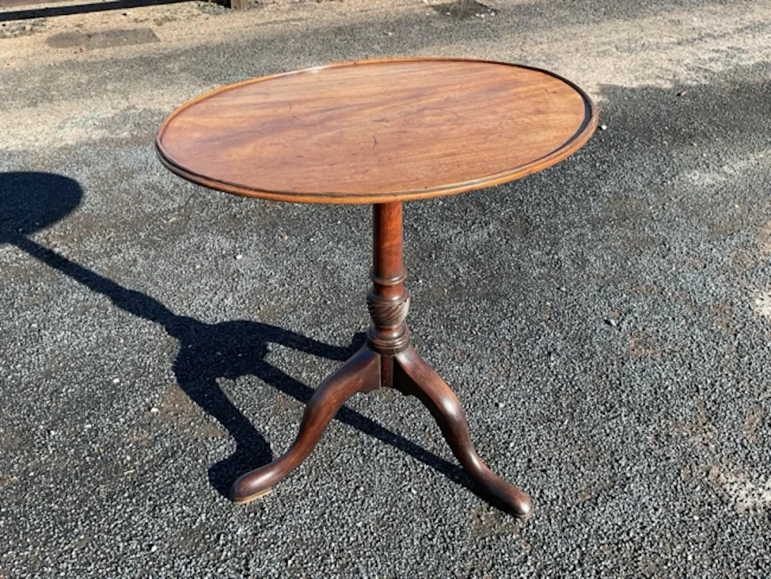 An oval Georgian tray top mahogany wine table, the snap-top supported