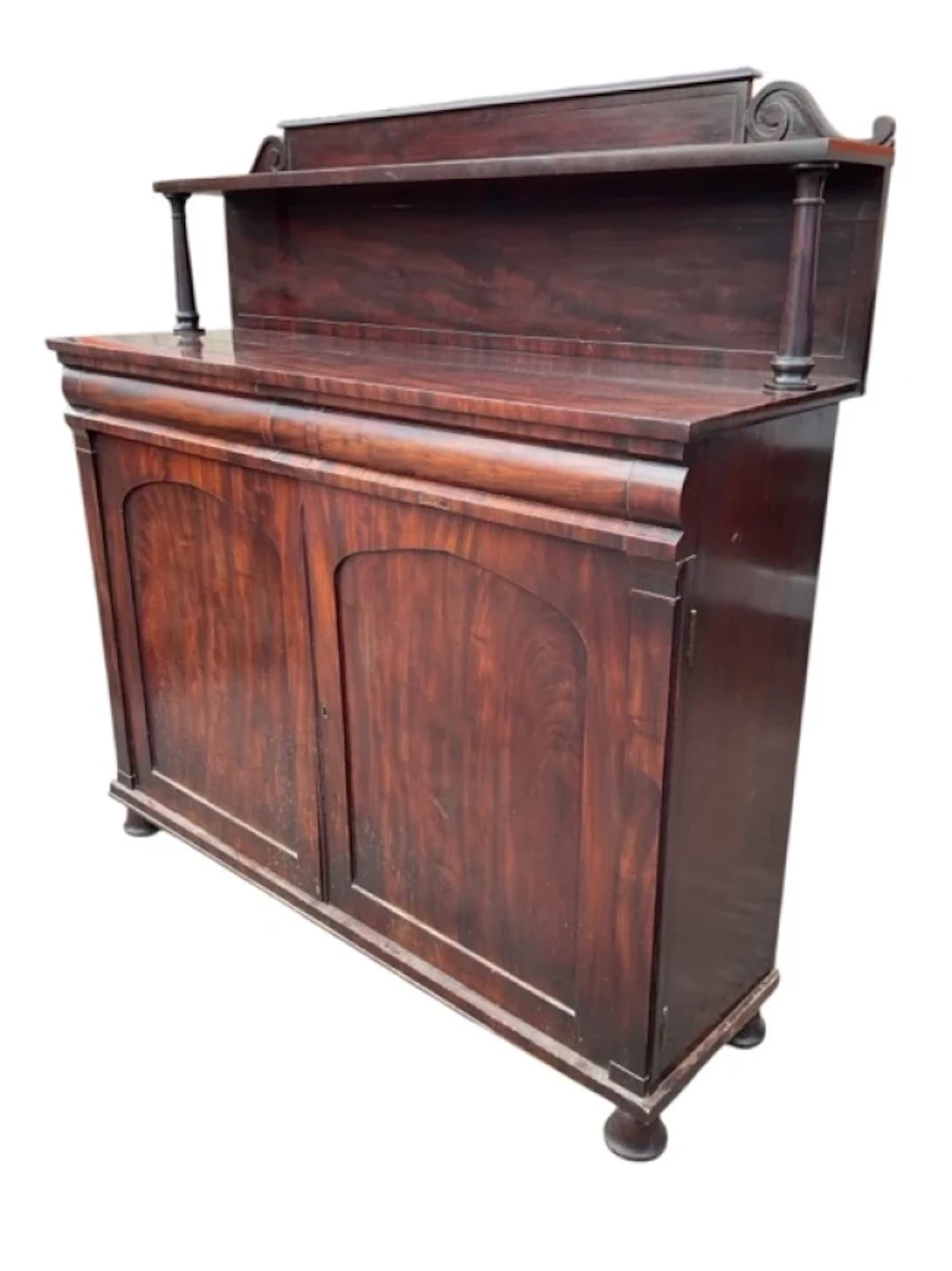 A regency mahogany chiffonier with scrolled panelled back having shelf