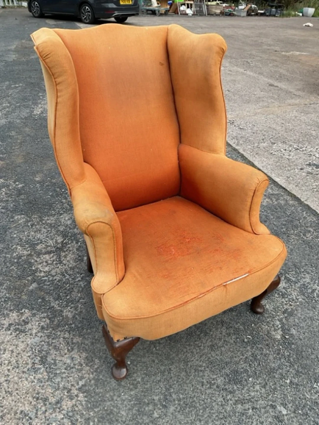 A Georgian style wing armchair with padded back and out-srolled arms