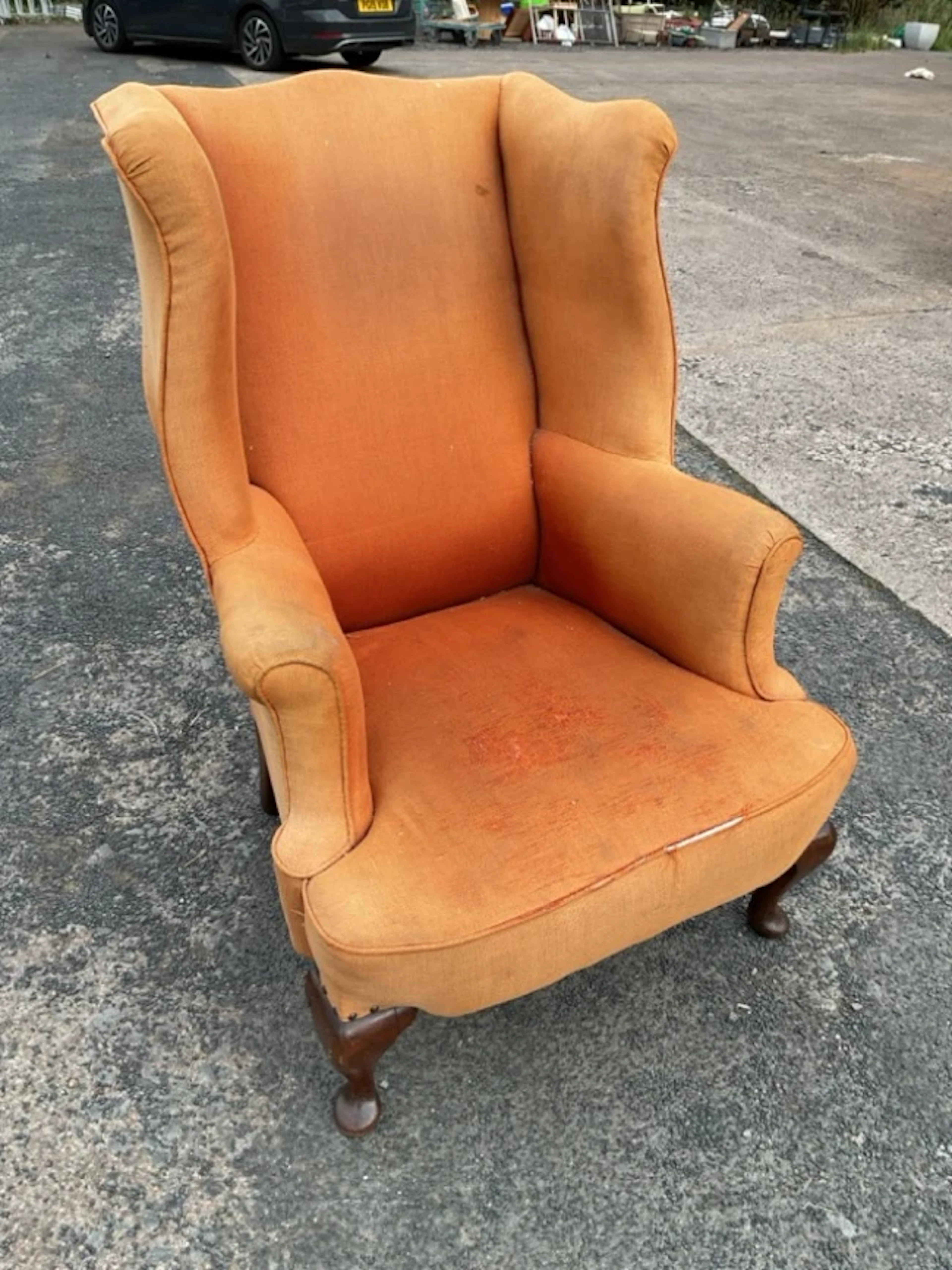 A Georgian style wing armchair with padded back and out-srolled arms