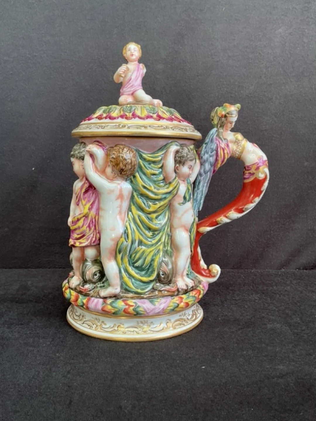 A C19th Naples handpainted porcelain tankard with drinking cherub
