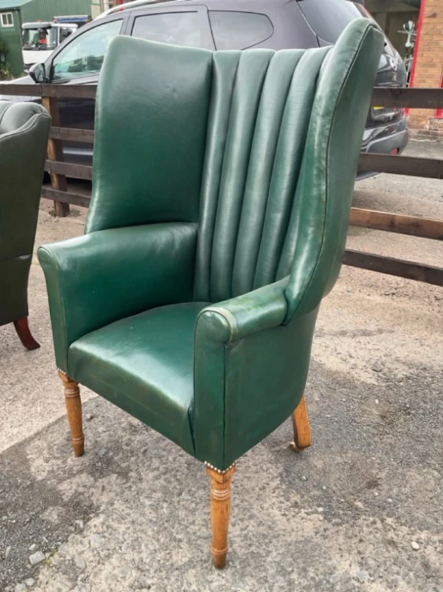 A Georgian style leather upholstered wing armchair with rectangular