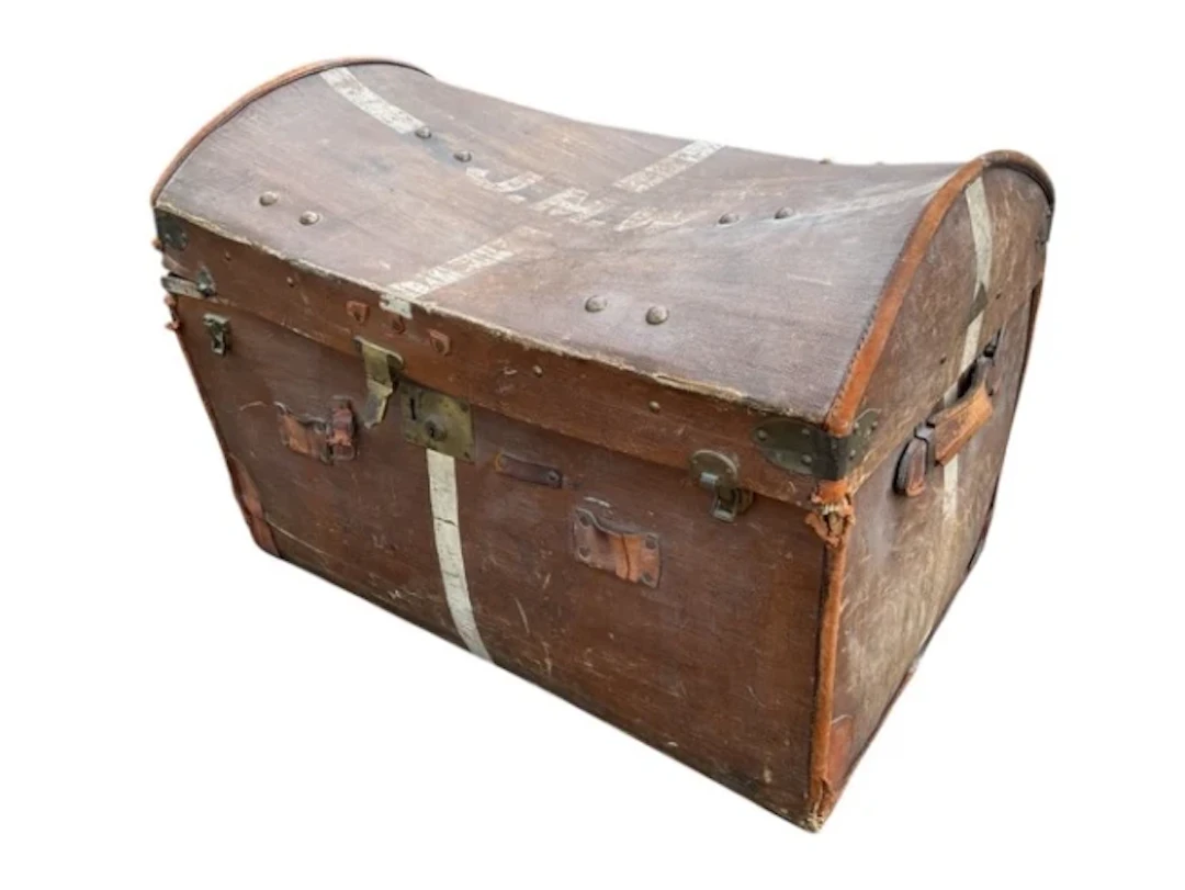 An Edwardian leather mounted studded trunk, the domed cover enclosing