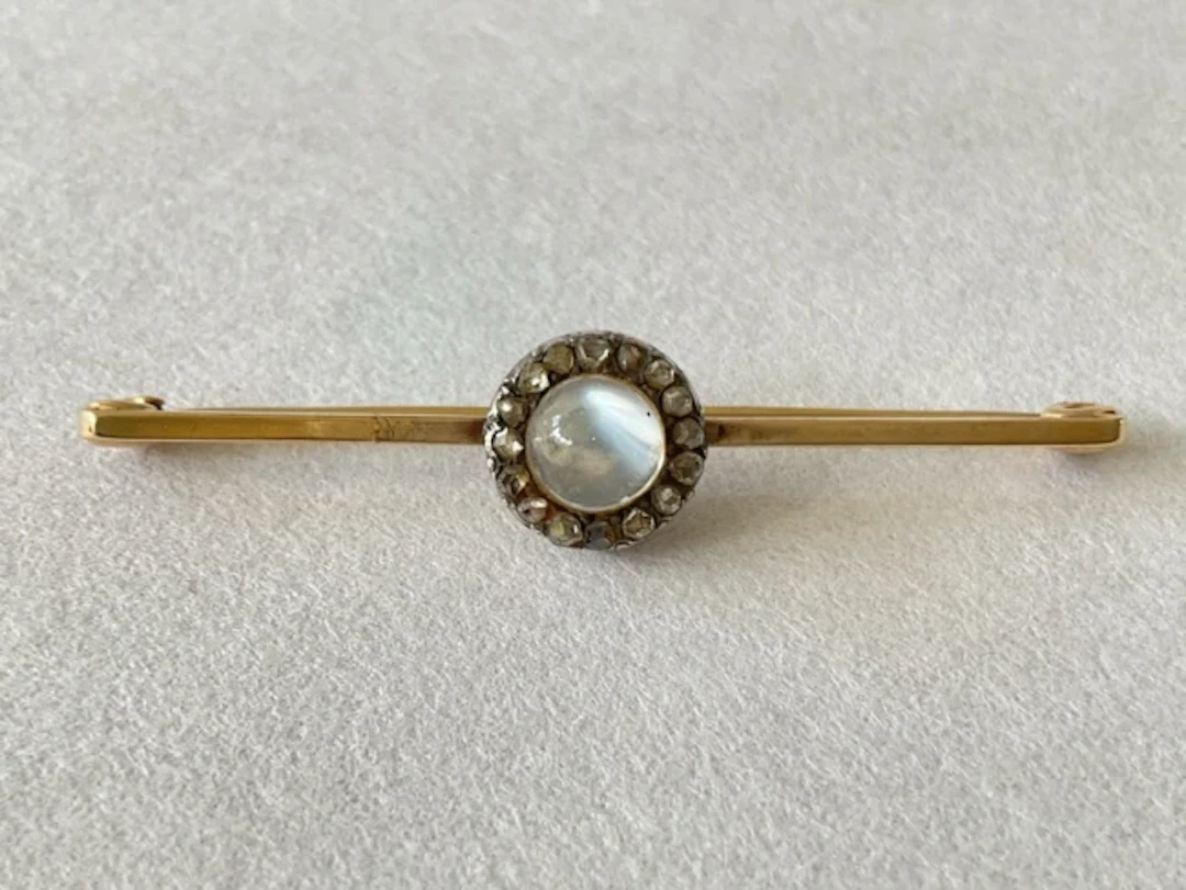 An antique 9ct gold bar brooch set with central cabochon moonstone