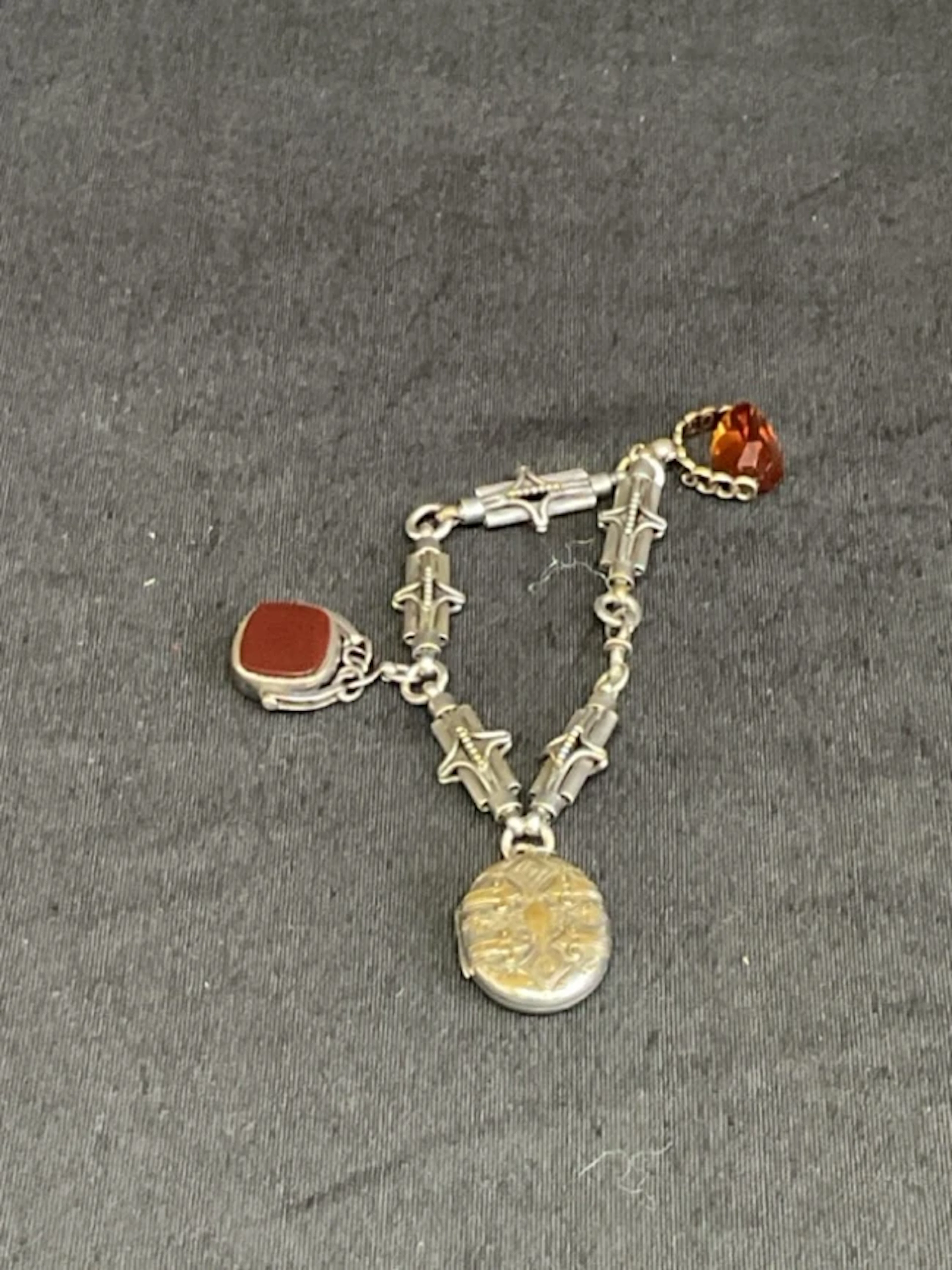 A Victorian silver plated fancy link bracelet suspending a plated