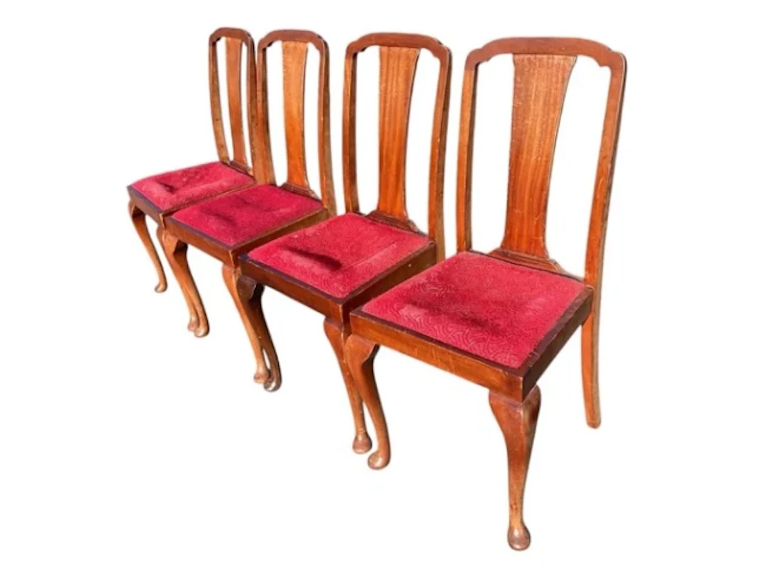 A set of four mahogany dining chairs with arched backs and tapering
