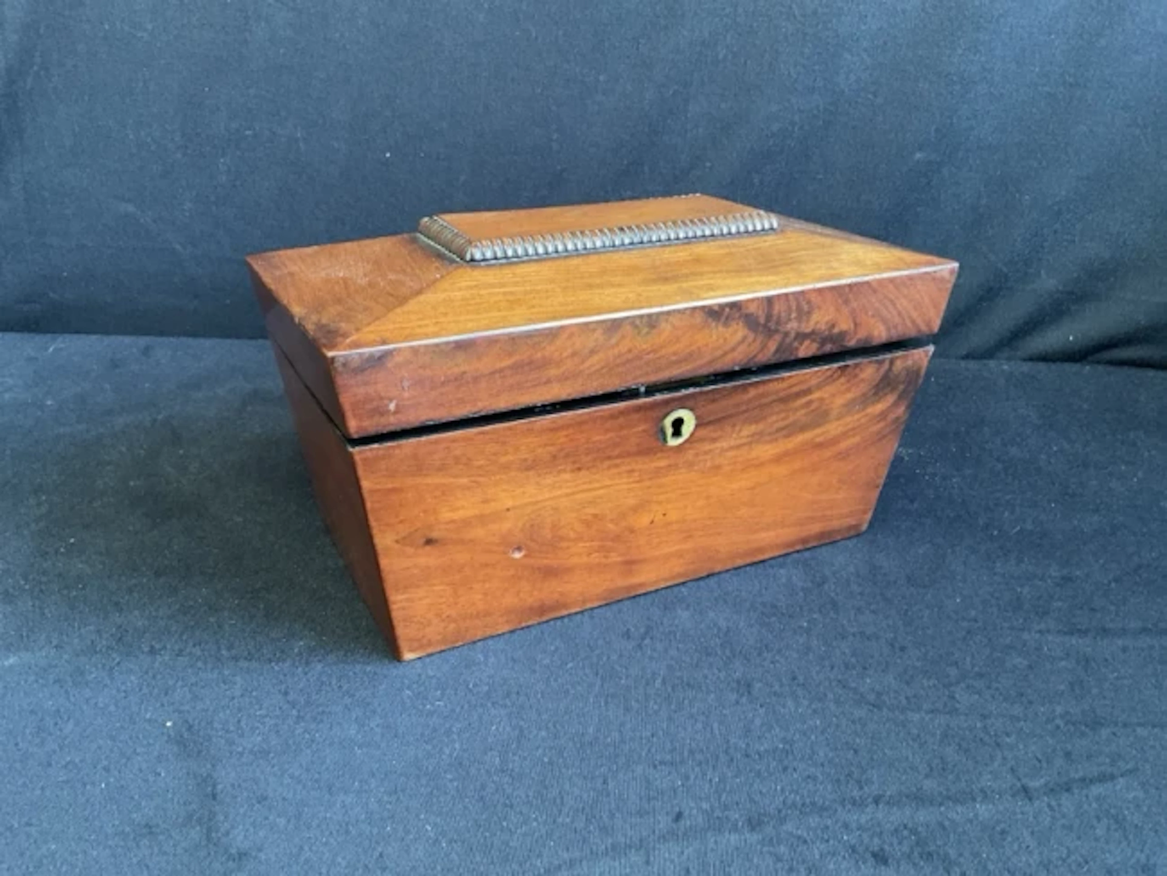 A Victorian mahogany tea caddy of sarcophagus shape with bead framed