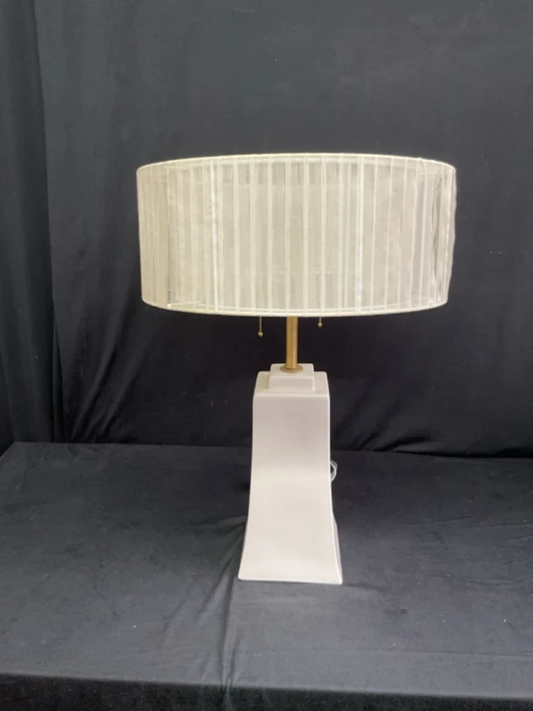A contemporary ceramic tablelamp with cylindrical organza ribbon shade