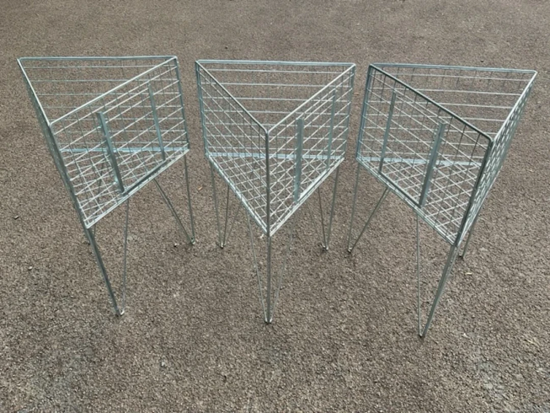 Three triangular display stands with mesh cages on angled legs. (21in