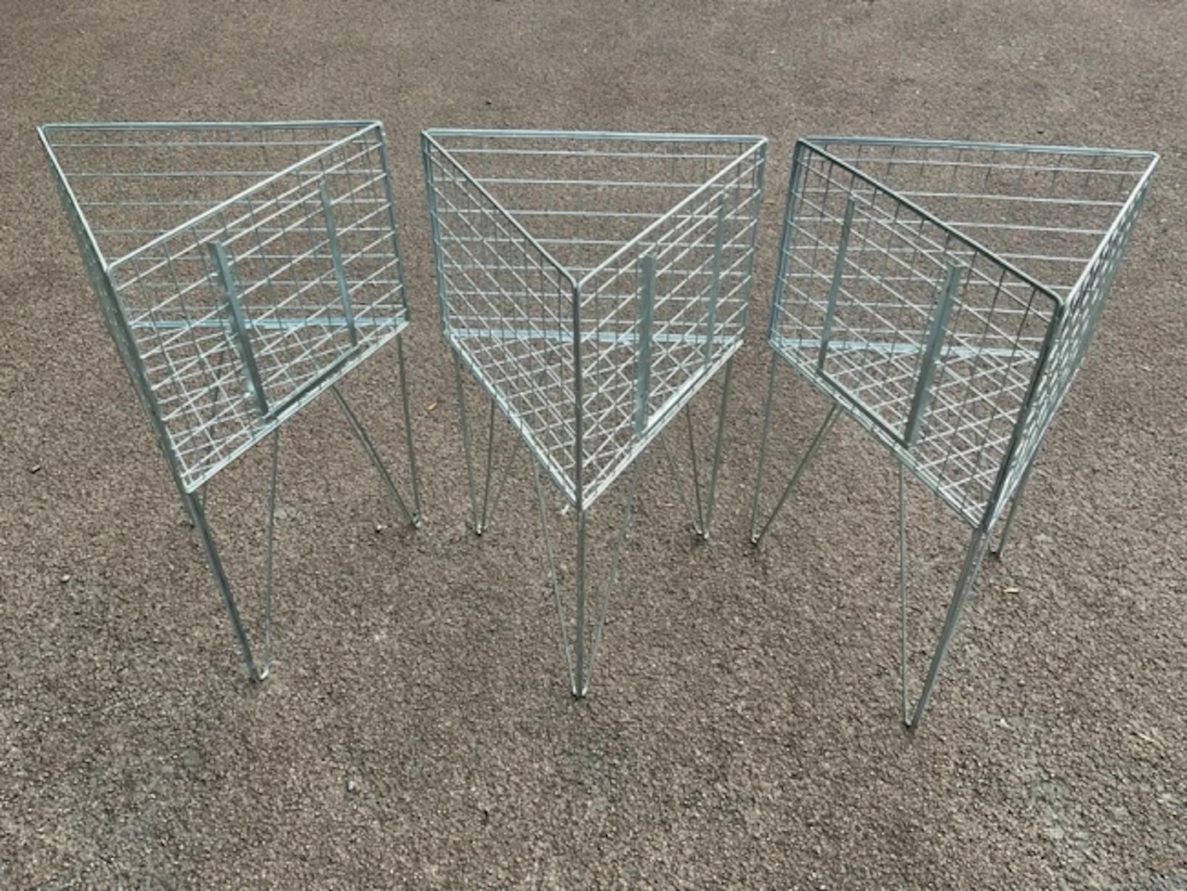 Three triangular display stands with mesh cages on angled legs. (21in