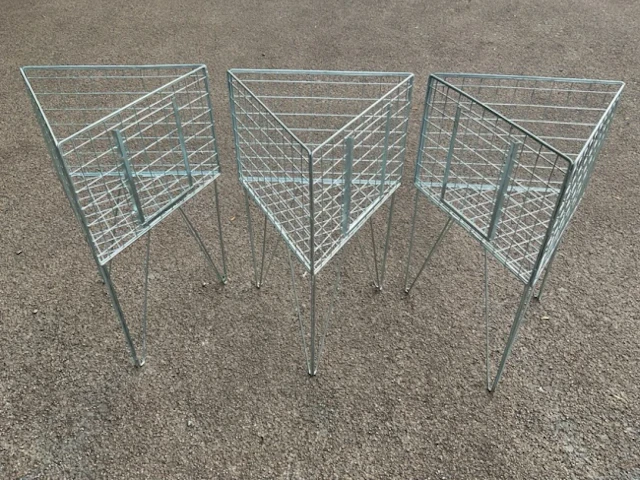 Three triangular display stands with mesh cages on angled legs. (21in