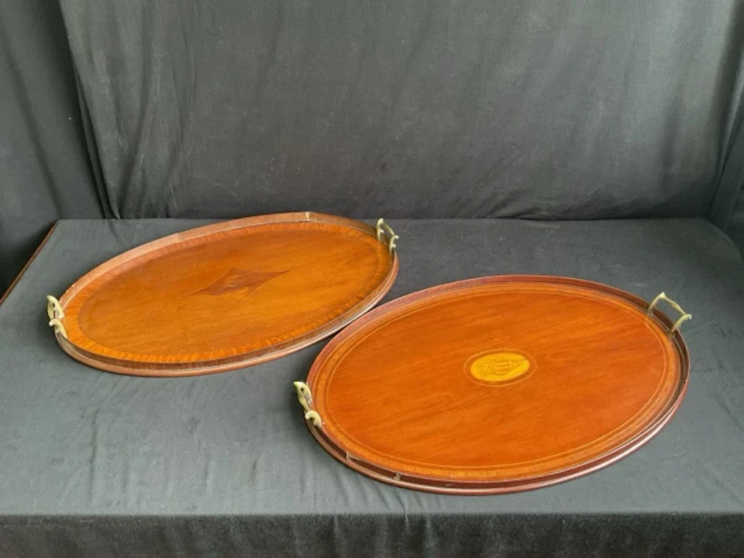 An oval Edwardian mahogany tray inlaid with central shell paterae