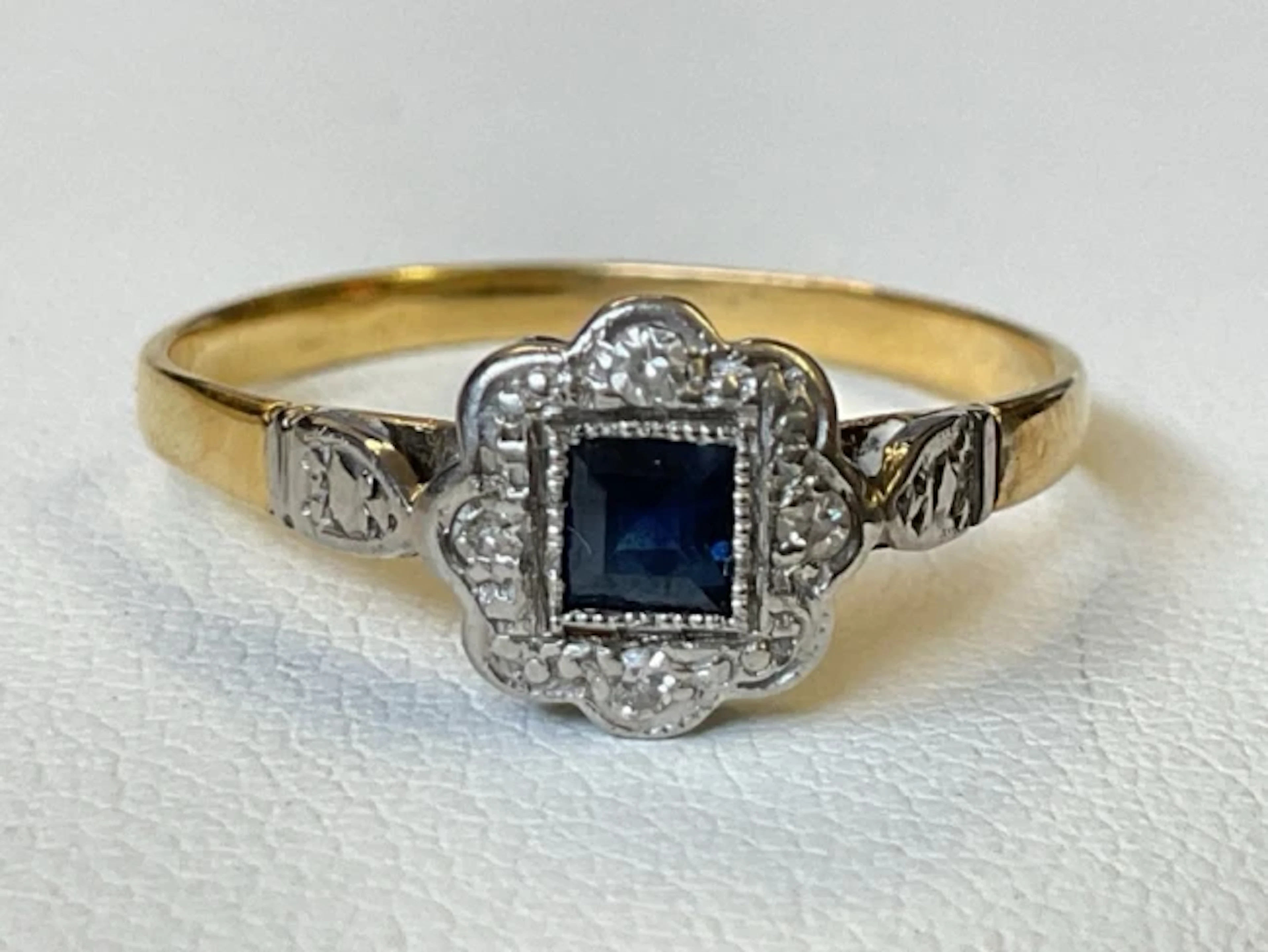 An antique 18ct gold ring with central princess cut sapphire and four
