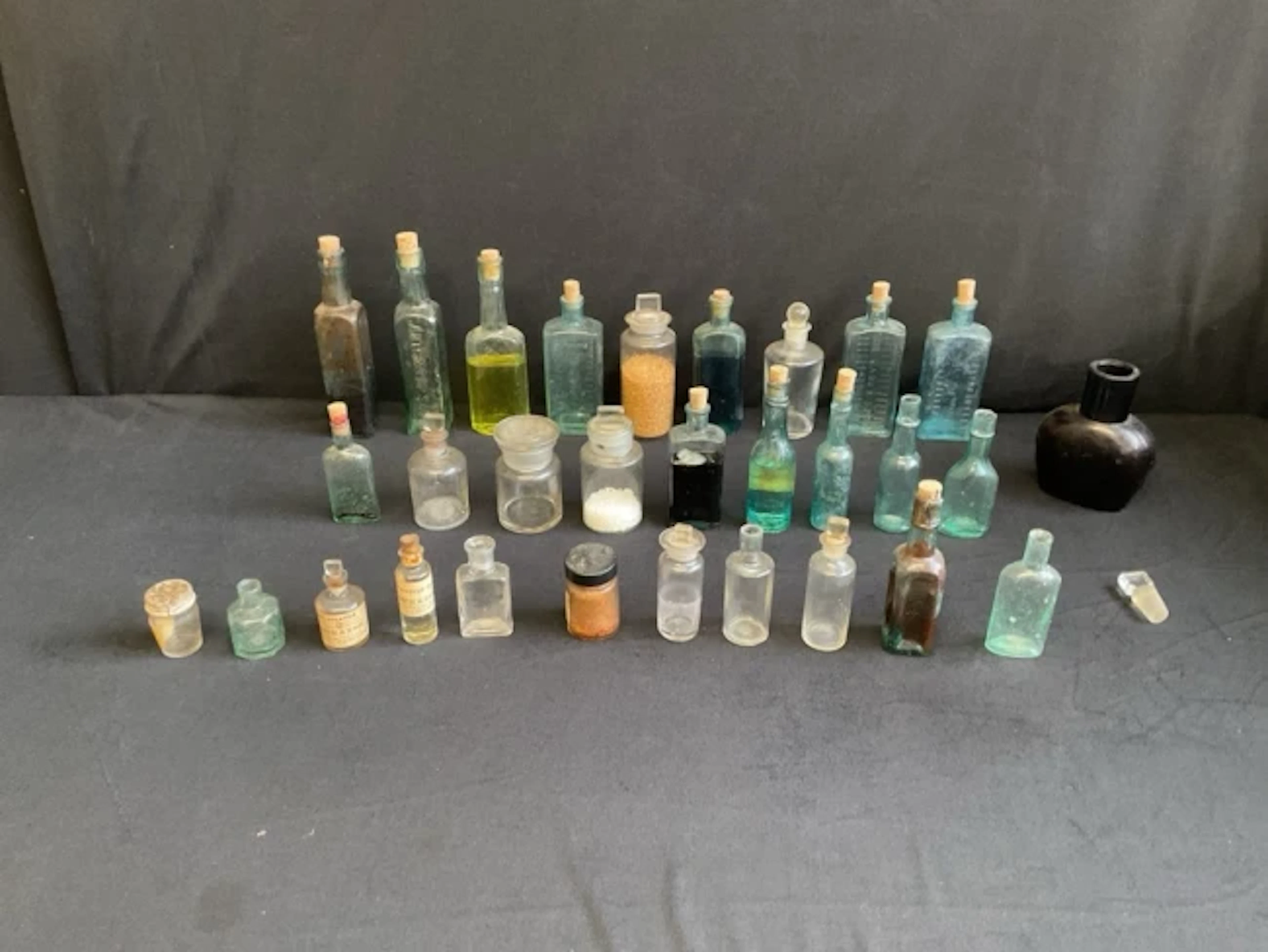 A collection of glass medicine bottles, pharmacy & toiletry jars
