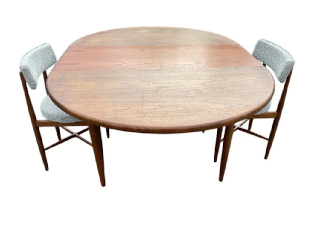 A circular teak G-plan dining table with integral folding extending