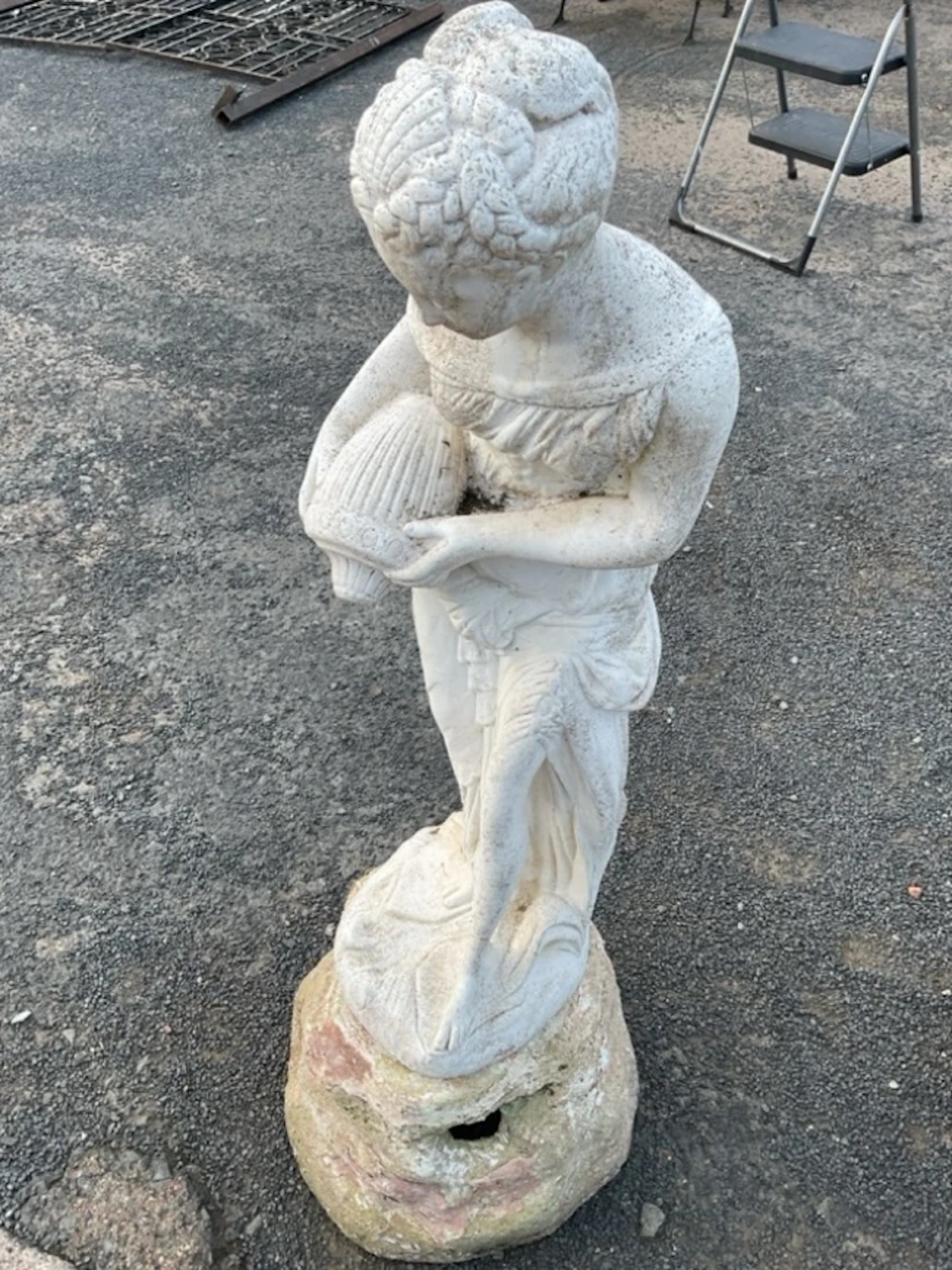 A painted composition stone garden sculpture cast as ‘the lady at