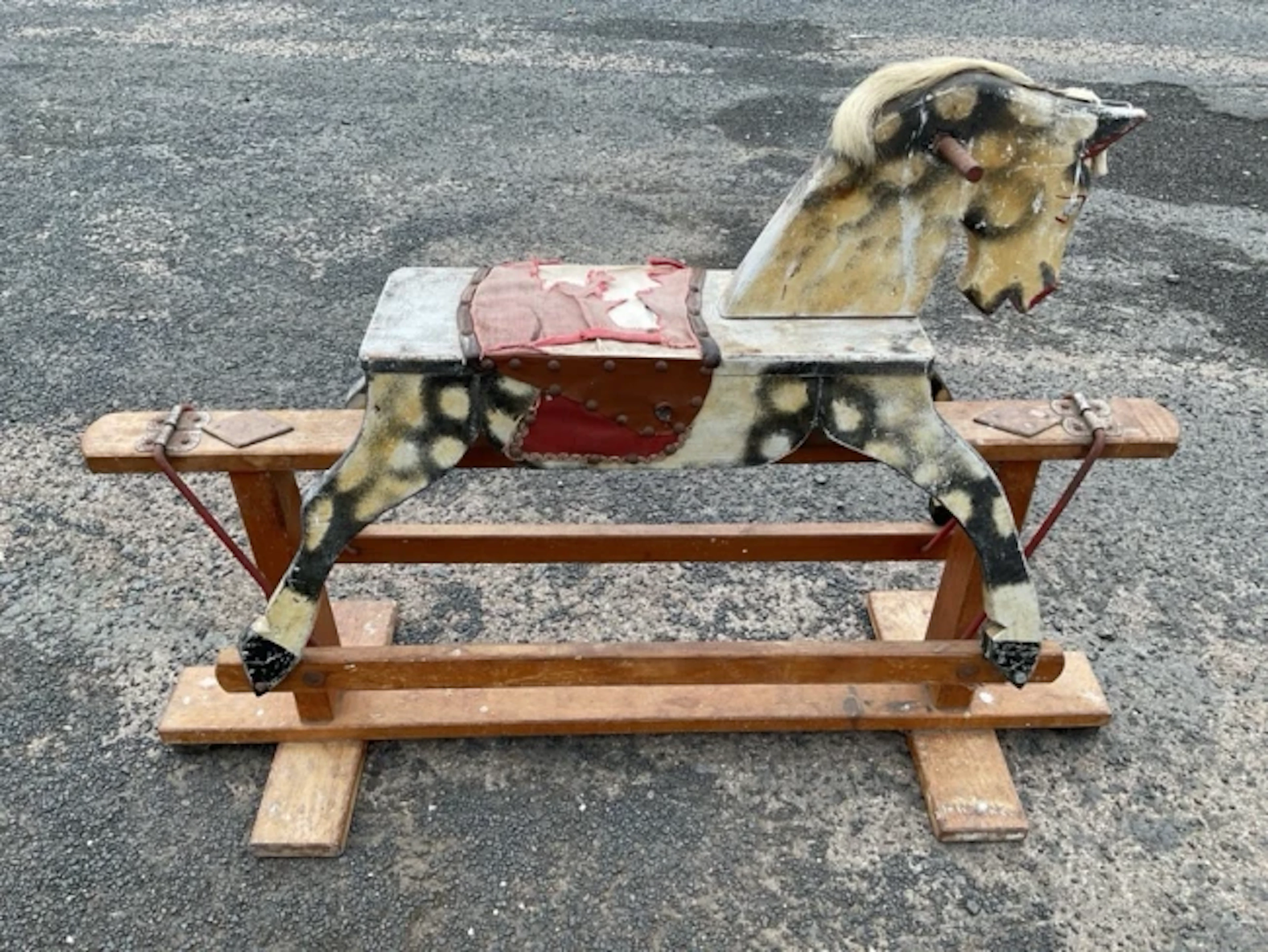 A painted childs rocking horse with studded saddle and hair mane