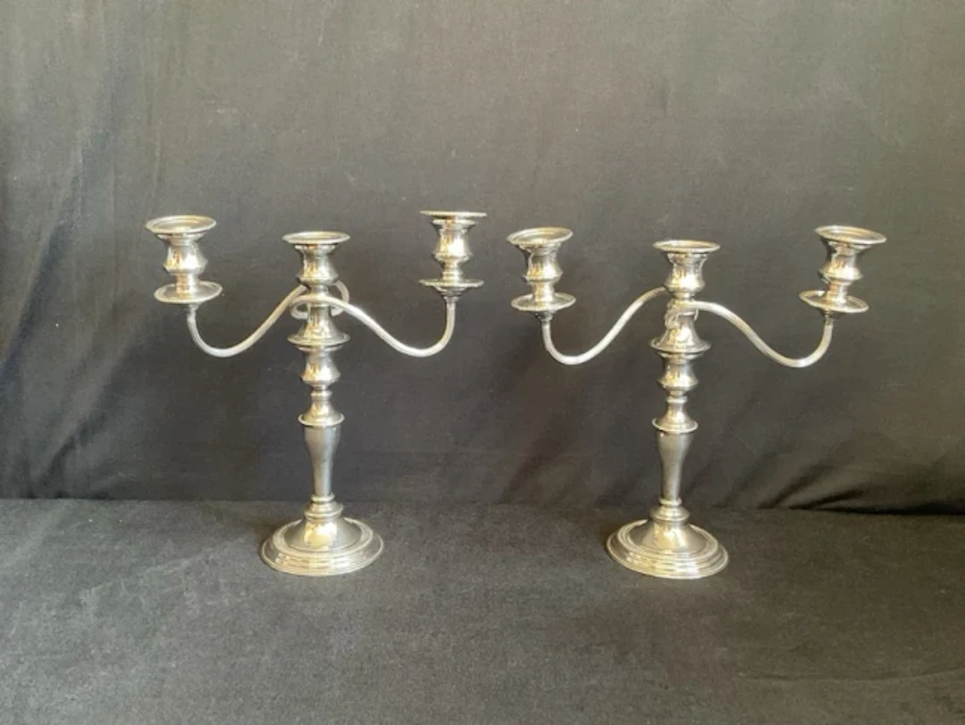 A pair of regency style silver plated on copper three-light candelabra