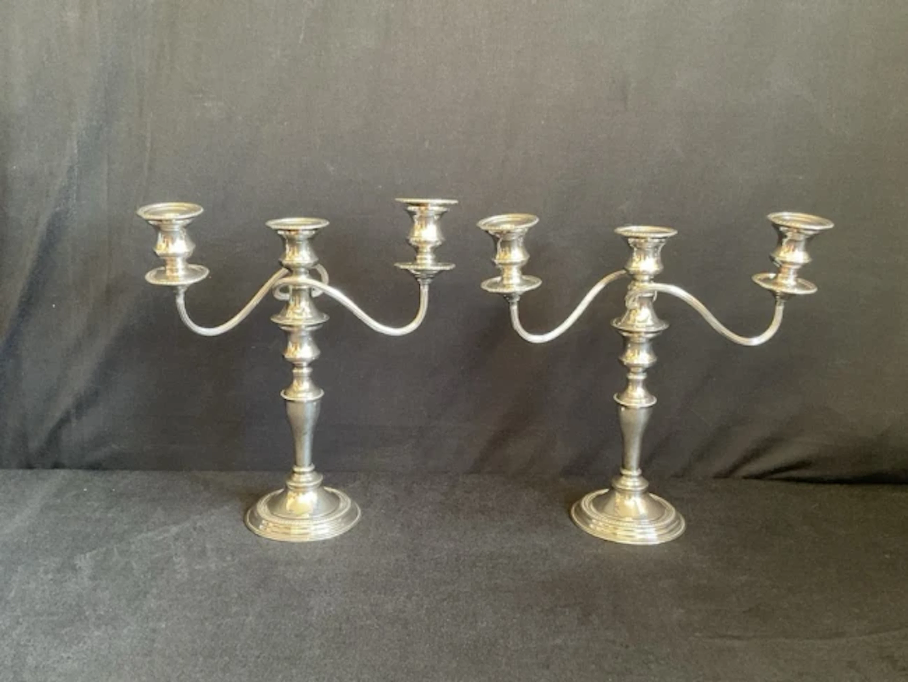 A pair of regency style silver plated on copper three-light candelabra