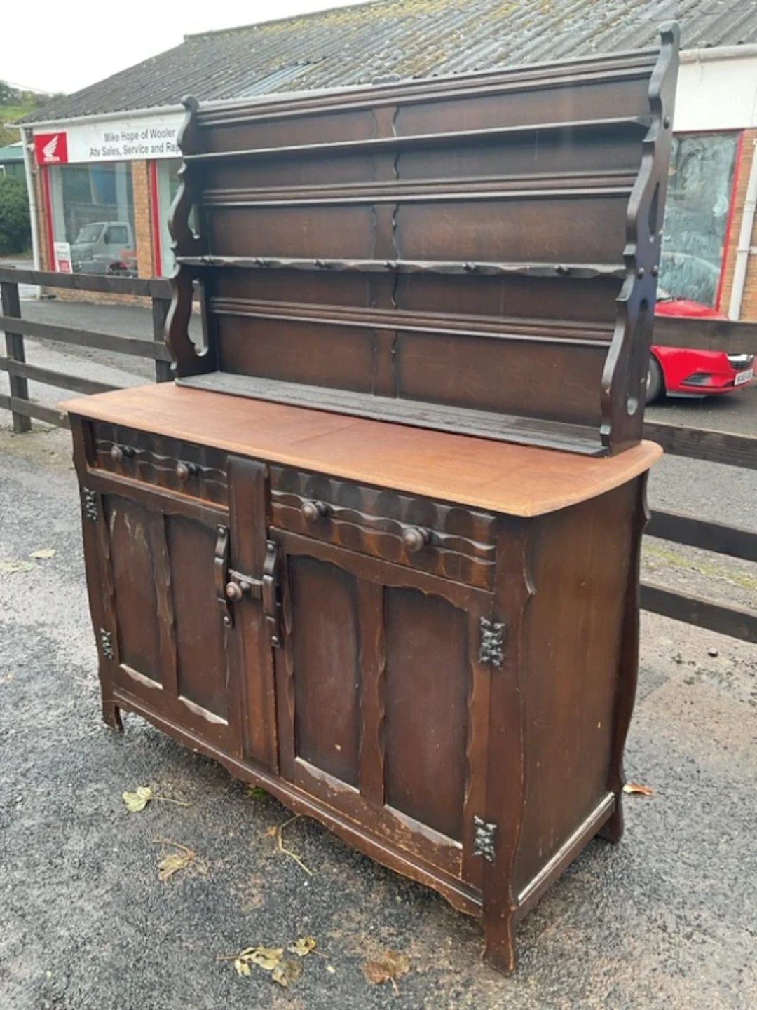 An oak dresser with delft rack having three plate shelves and pegs