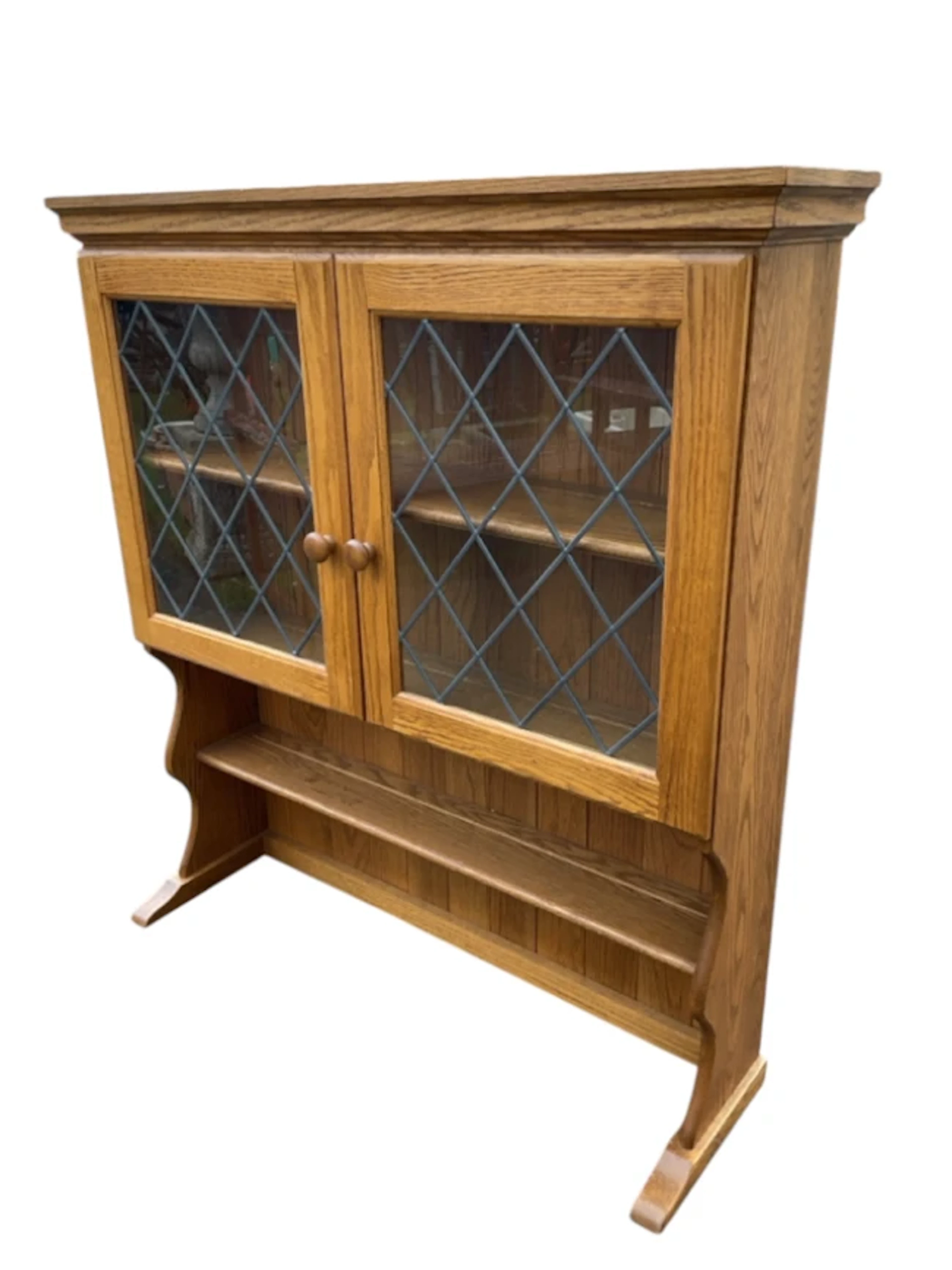 An oak dresser wall cabinet with moulded cornice above a pair of leaded