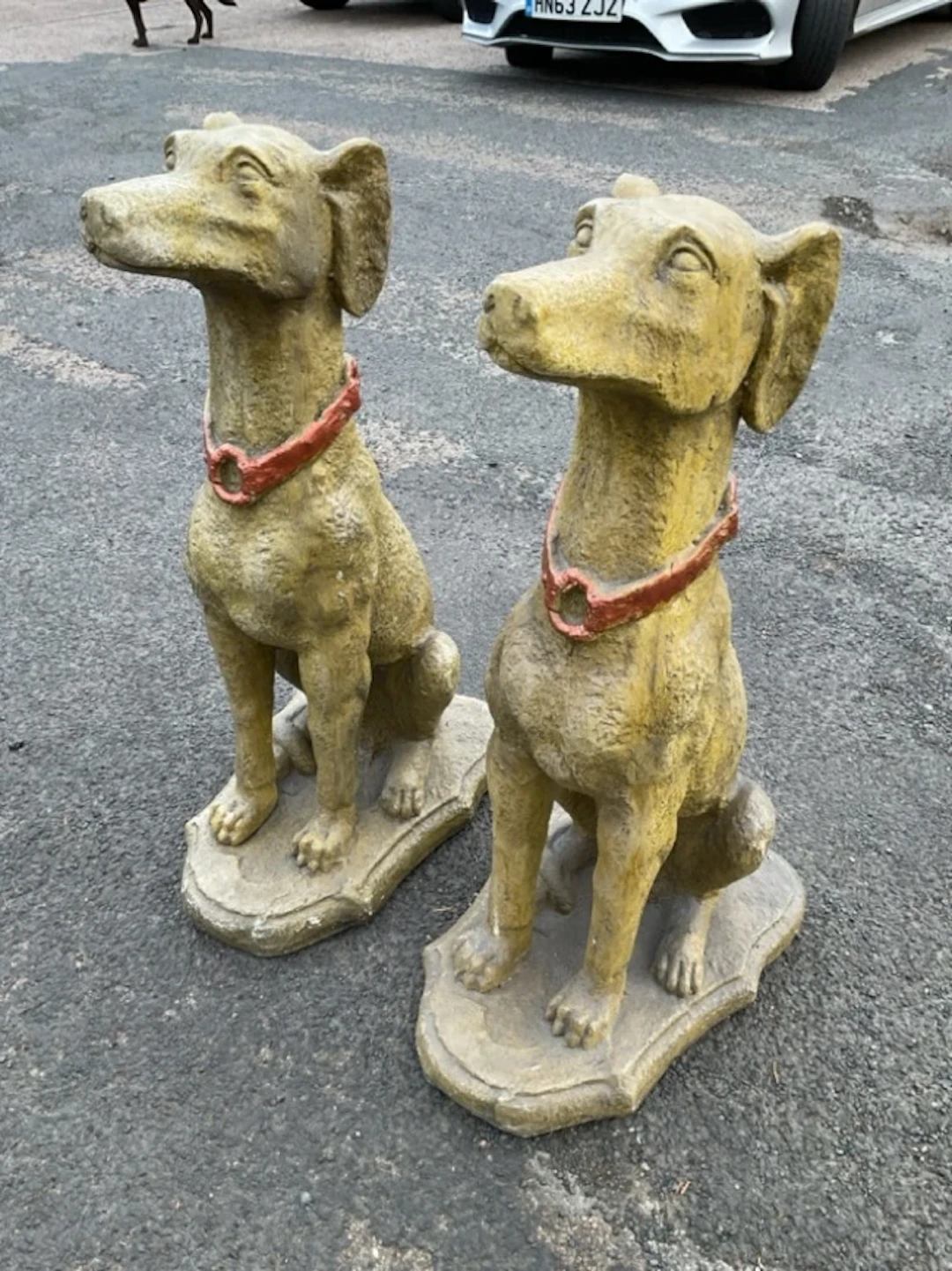 A pair of painted composition dogs, the pround animals seated on their