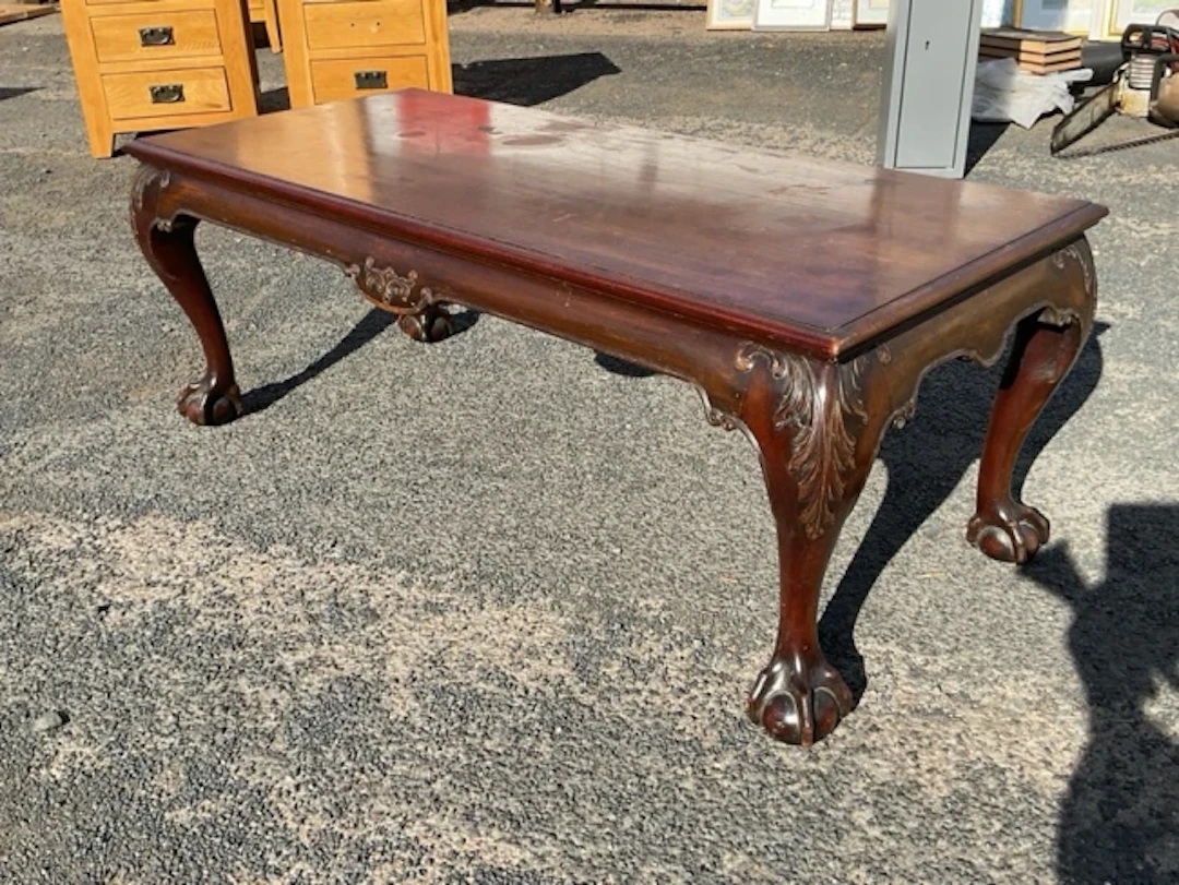 A rectangular mahogany coffee table with moulded top on acanthus scroll