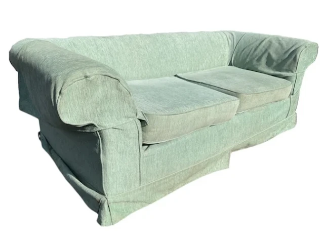 A contemporary country house chesterfield sofa with loose covers